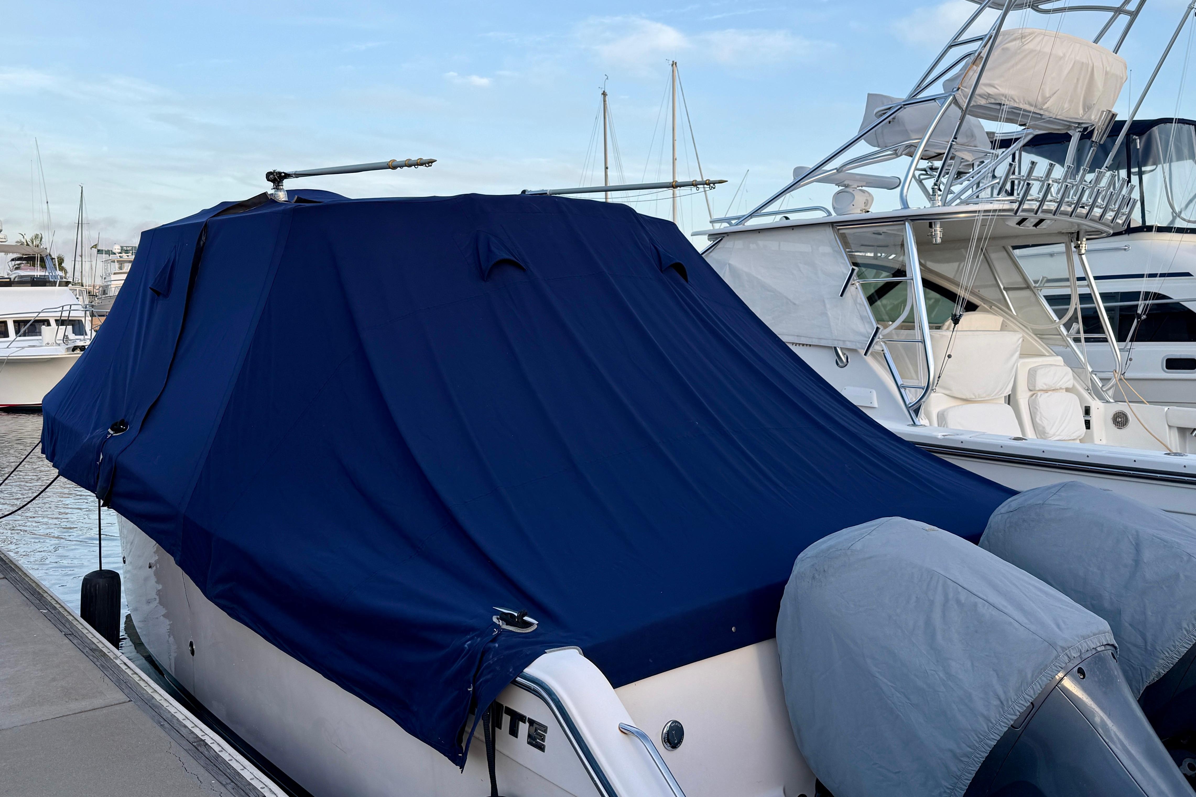 2012 Grady-White Canyon 336 boat covered with a blue tarp at a marina.