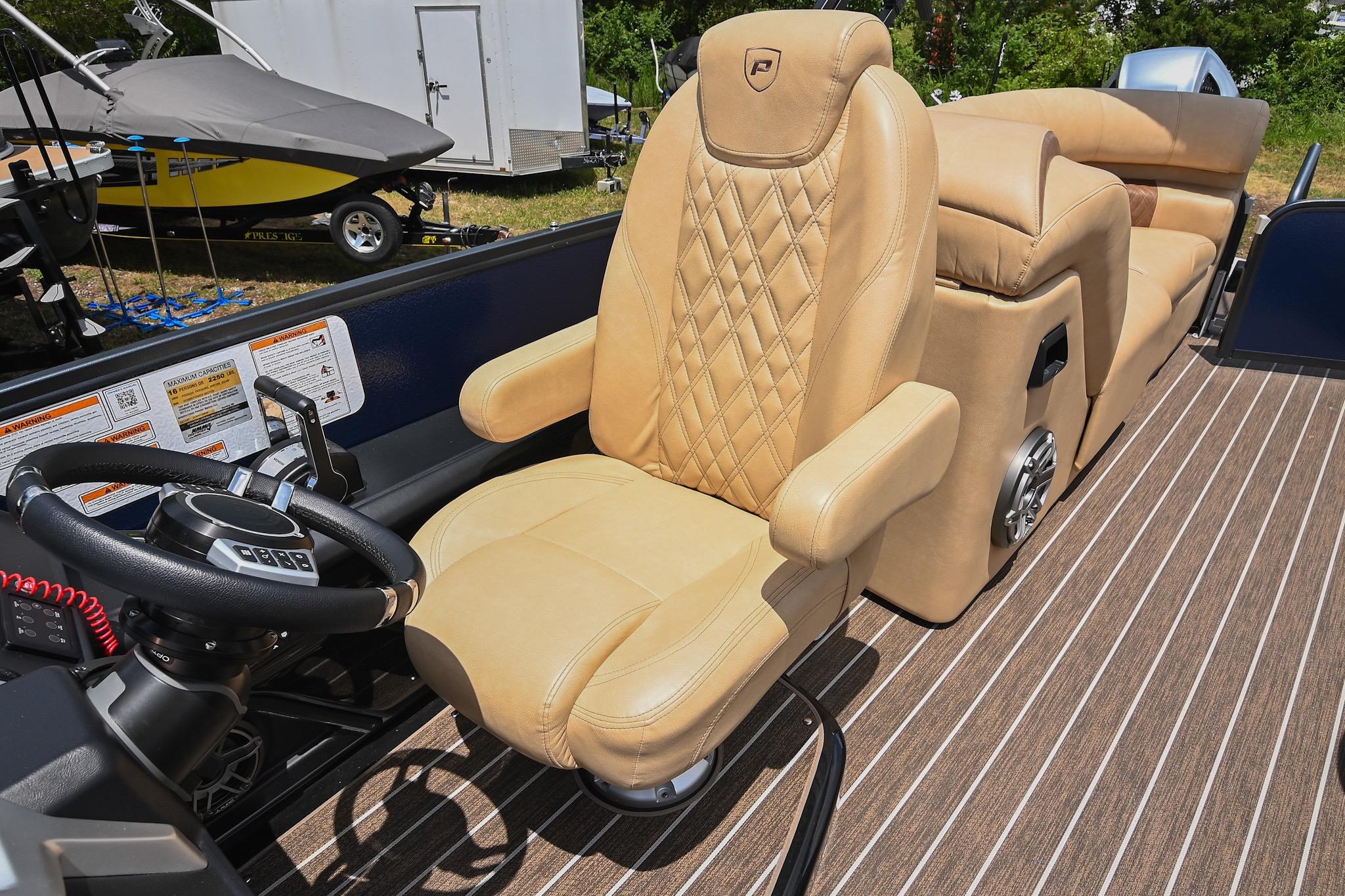 Luxurious seating in 2023 Premier 270 Intrigue RF boat with tan upholstery and steering wheel.