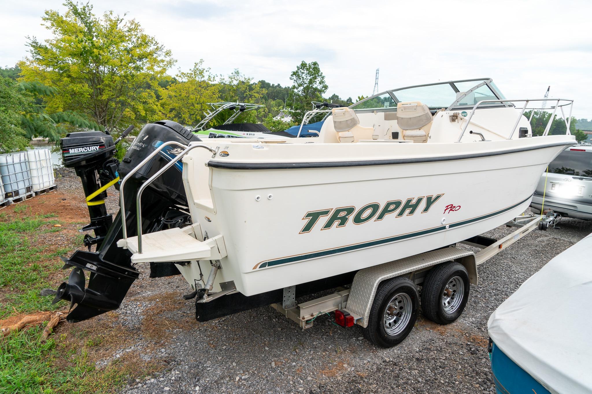 2002 Bayliner 2302 Trophy Walkaround boat on trailer, featuring Mercury outboard motor.