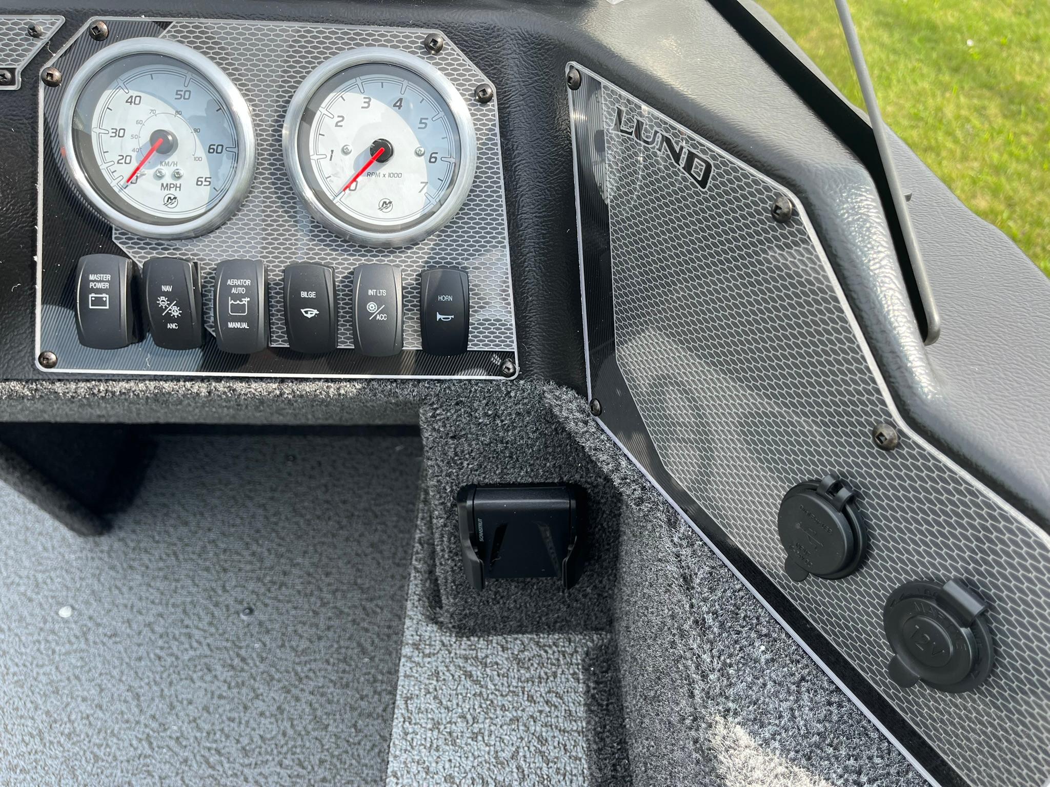 Dashboard of 2026 Lund 1650 Angler SS boat with gauges and switches.