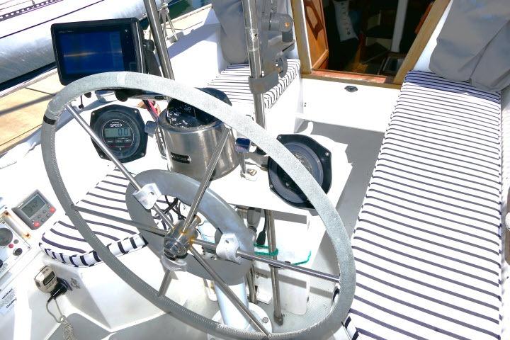 Cockpit of 1989 Catalina 34 sailboat with striped cushions and navigation instruments.