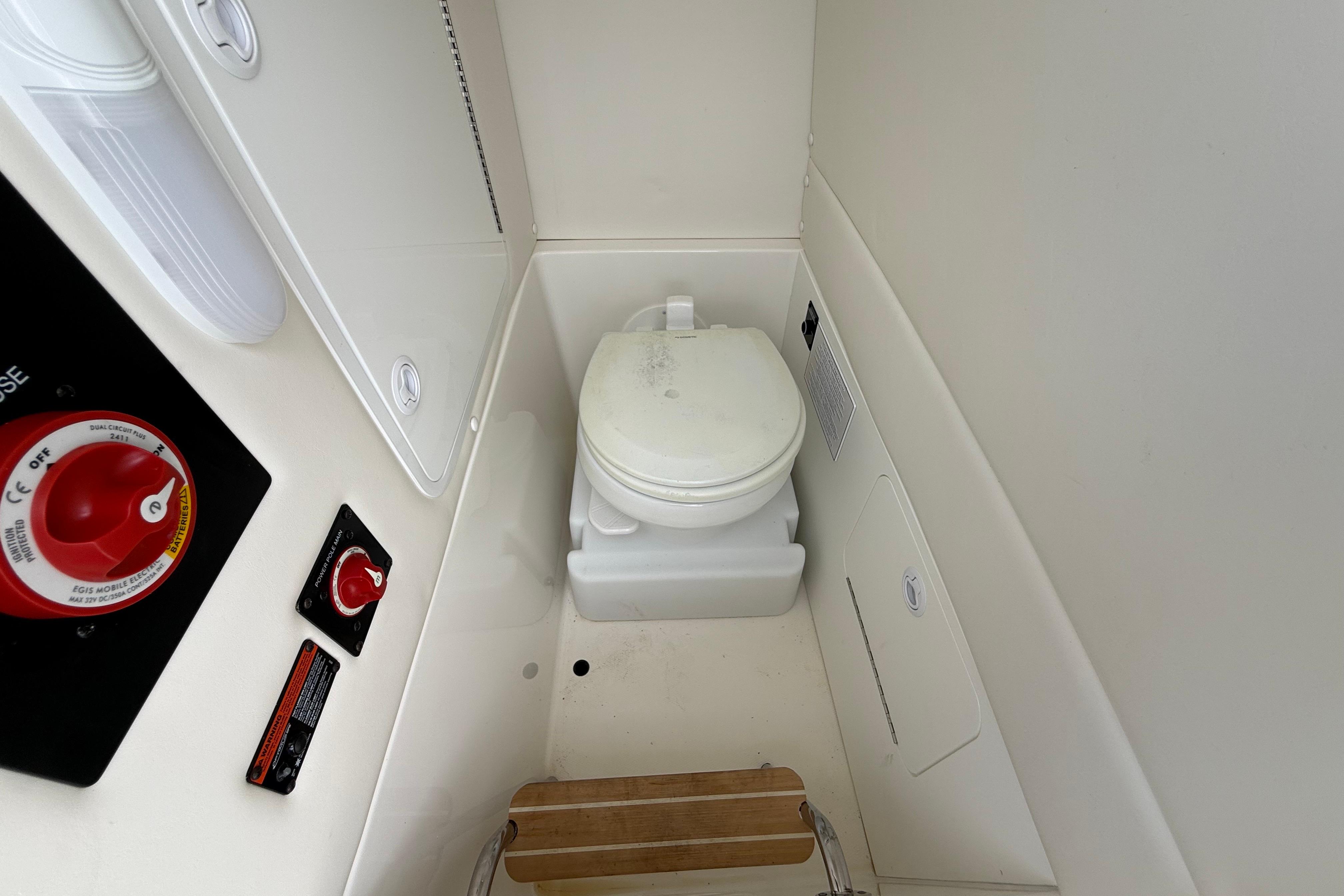 2019 Regulator 26XO boat interior with compact marine toilet and control panel.