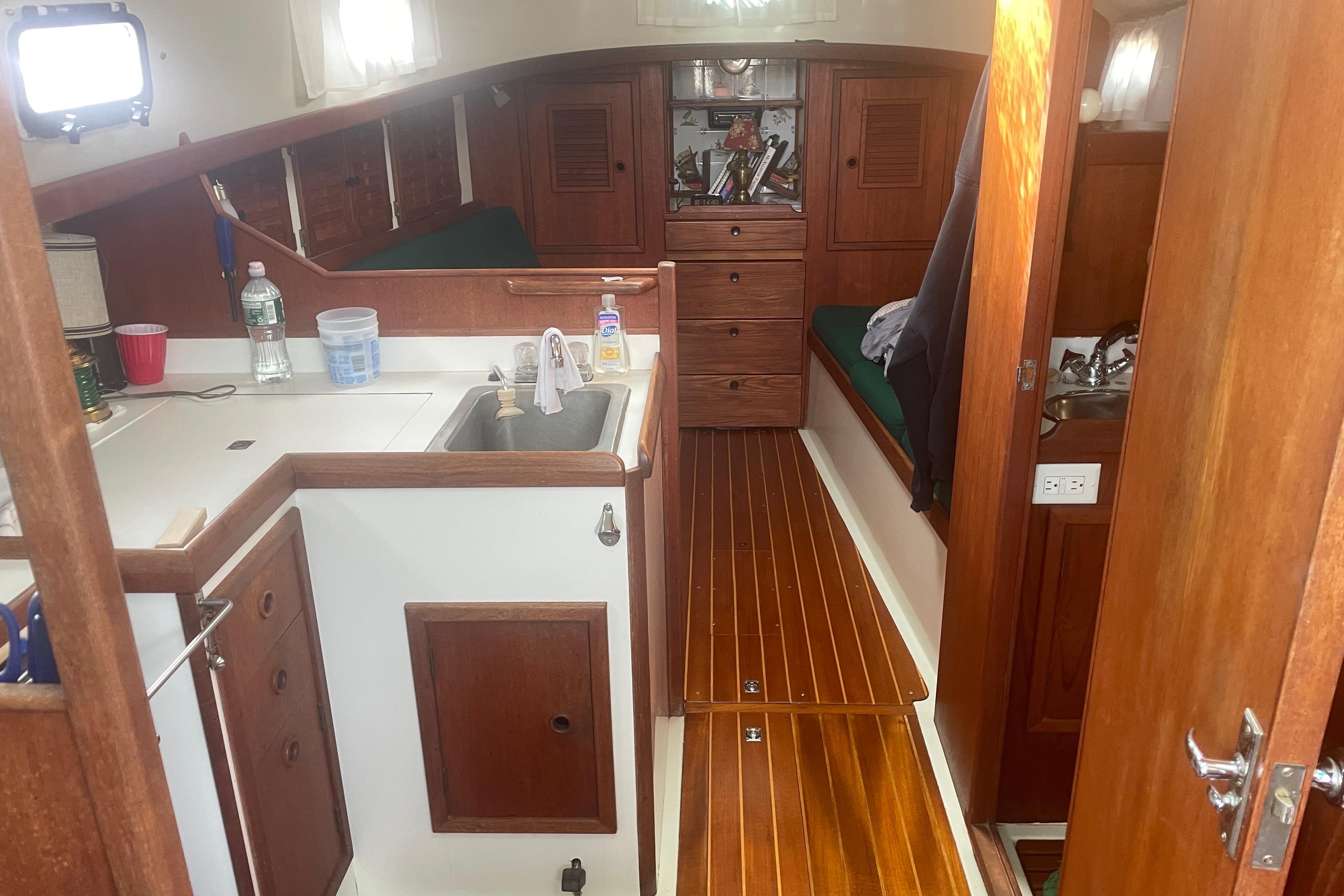 Interior of 1981 Nonsuch 30 Classic sailboat with wooden cabinetry and compact kitchen.