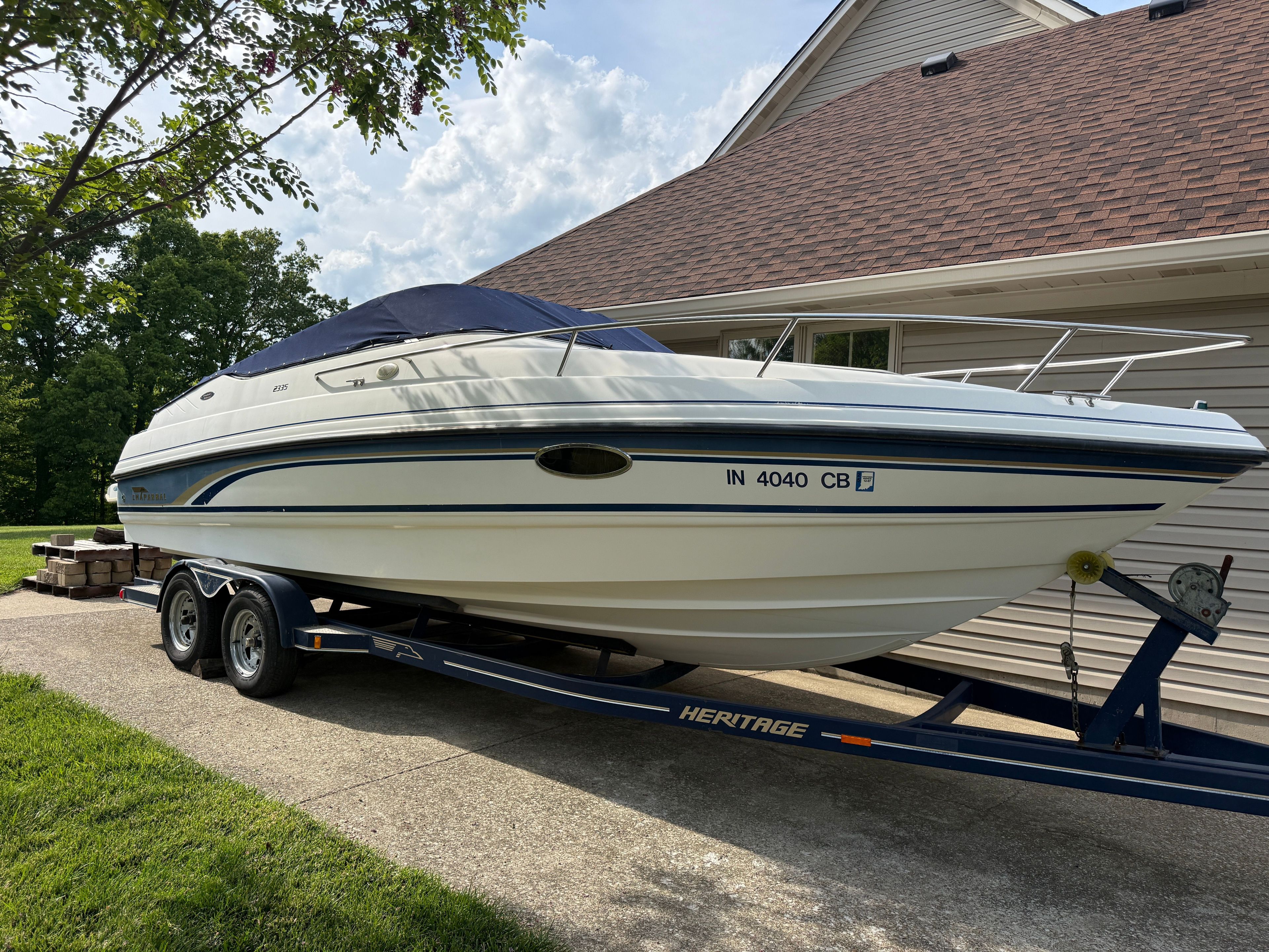 1999 Custom 2335 Cuddy cabin boat on trailer by garage.