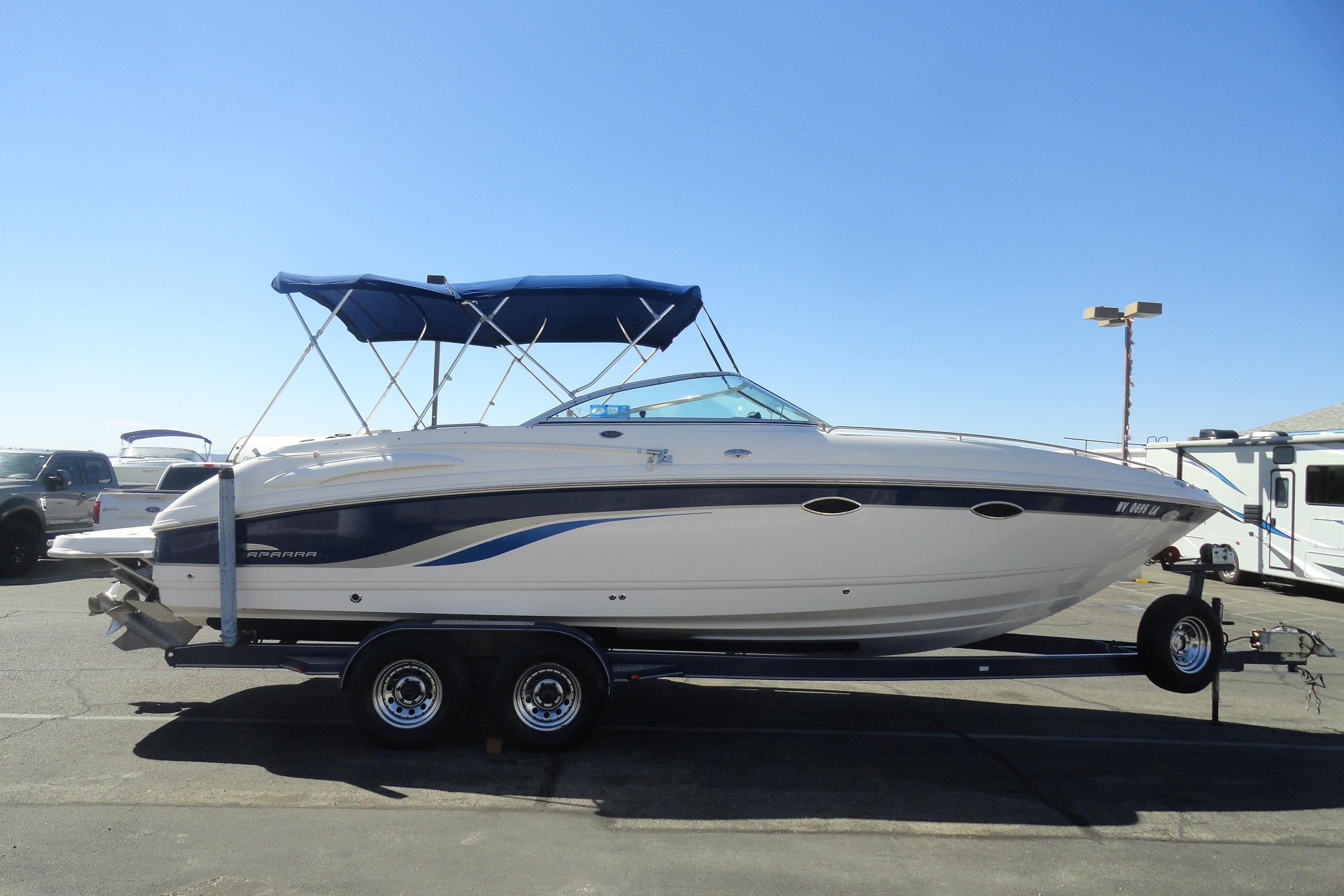 2001 Chaparral 265 SSi boat on trailer with blue canopy, parked outdoors.