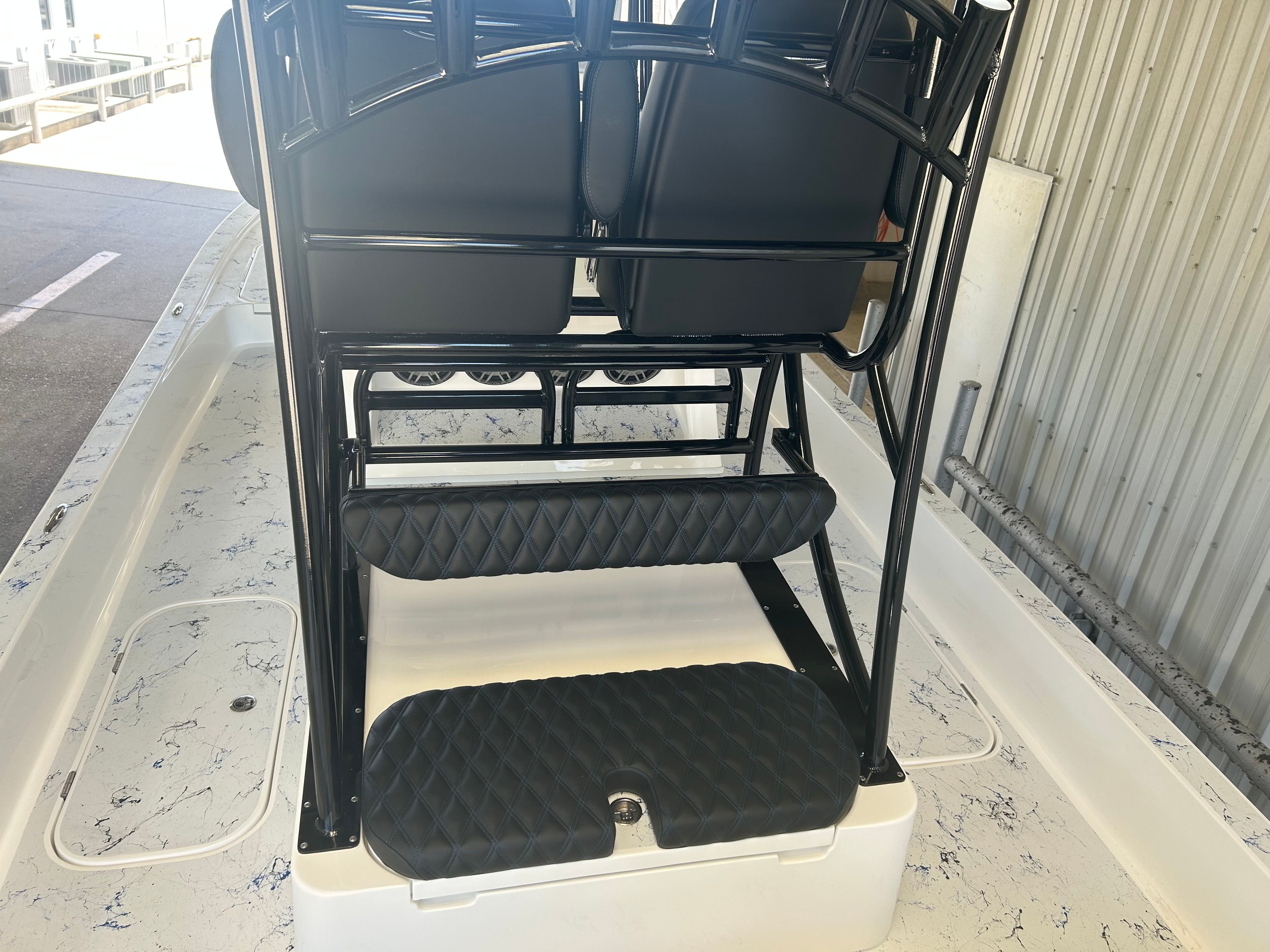 Shallow Sport 25 X3 2023 boat with cushioned seats and black frame.