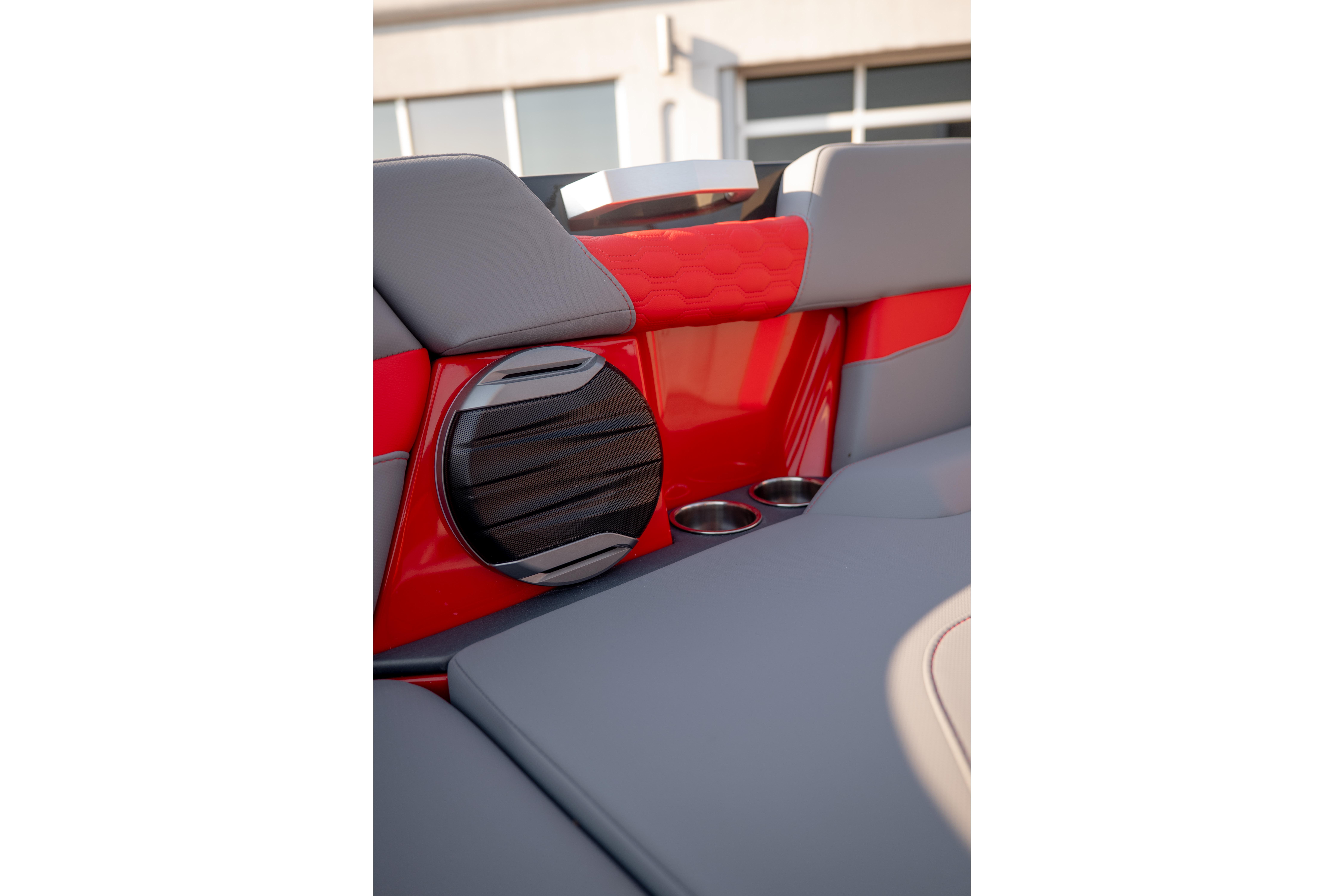 Interior of 2027 MasterCraft XT24 boat with red and gray seating, speaker, and cup holders.