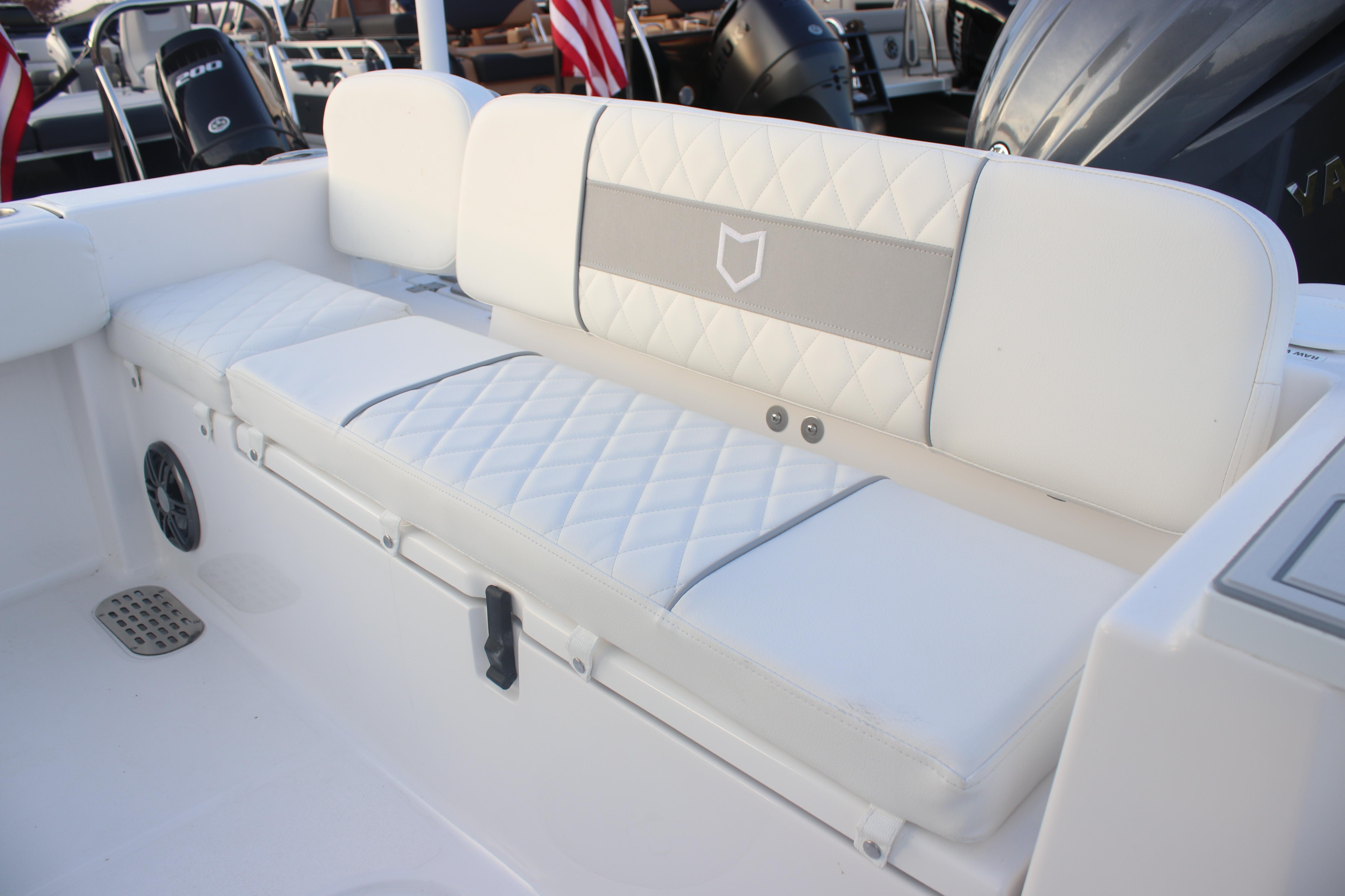 2026 Sea Fox 228 Commander boat interior with white cushioned seating and speaker.