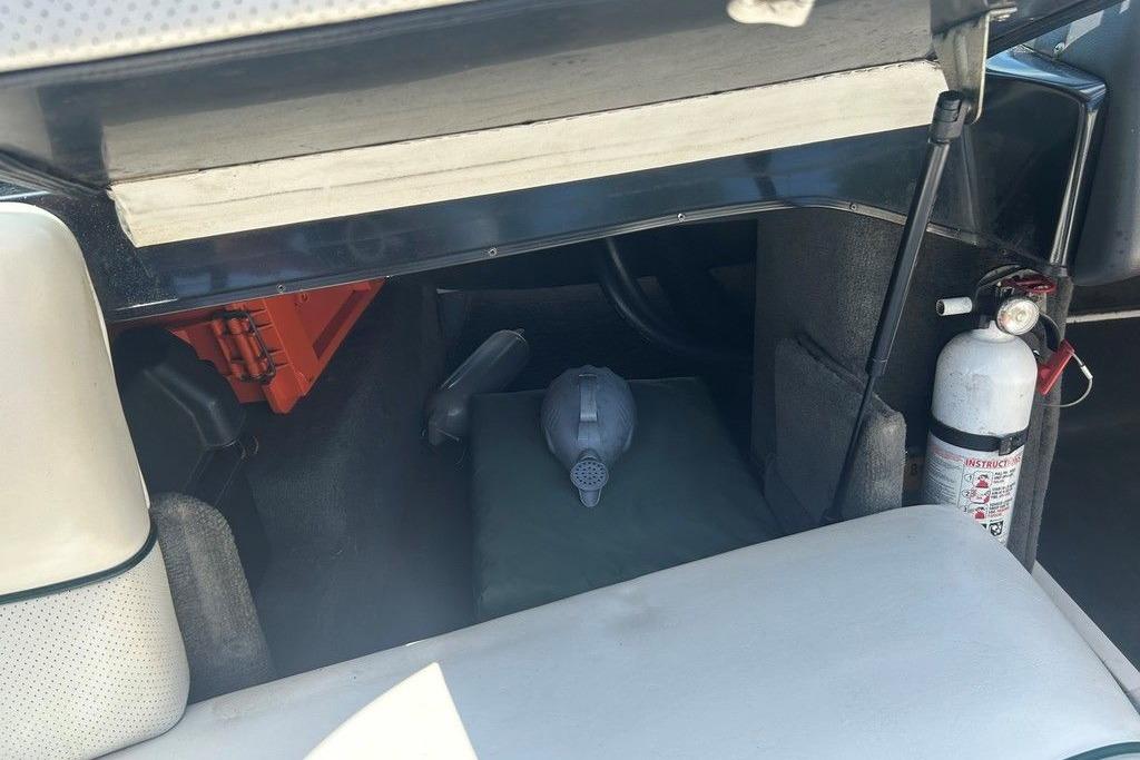 Interior of a 1999 Malibu Response boat with safety equipment and storage.