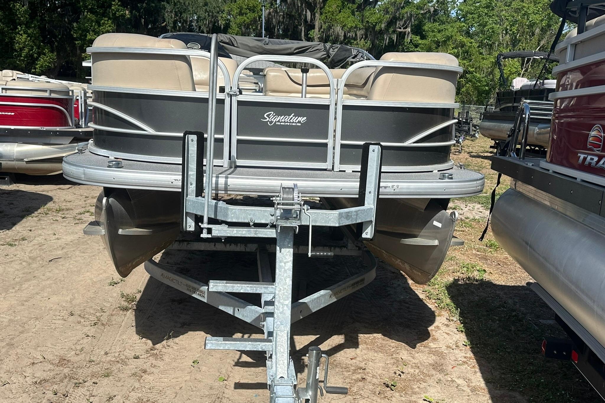 2016 SUNTRACKER Party Barge 20 pontoon boat on trailer, parked outdoors.