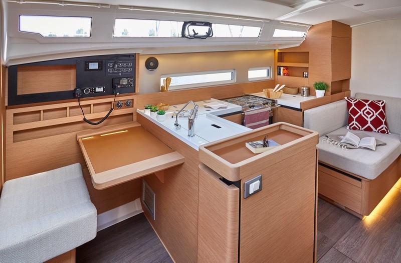 Modern interior of 2026 Jeanneau Sun Odyssey 410 yacht with sleek kitchen and seating area.