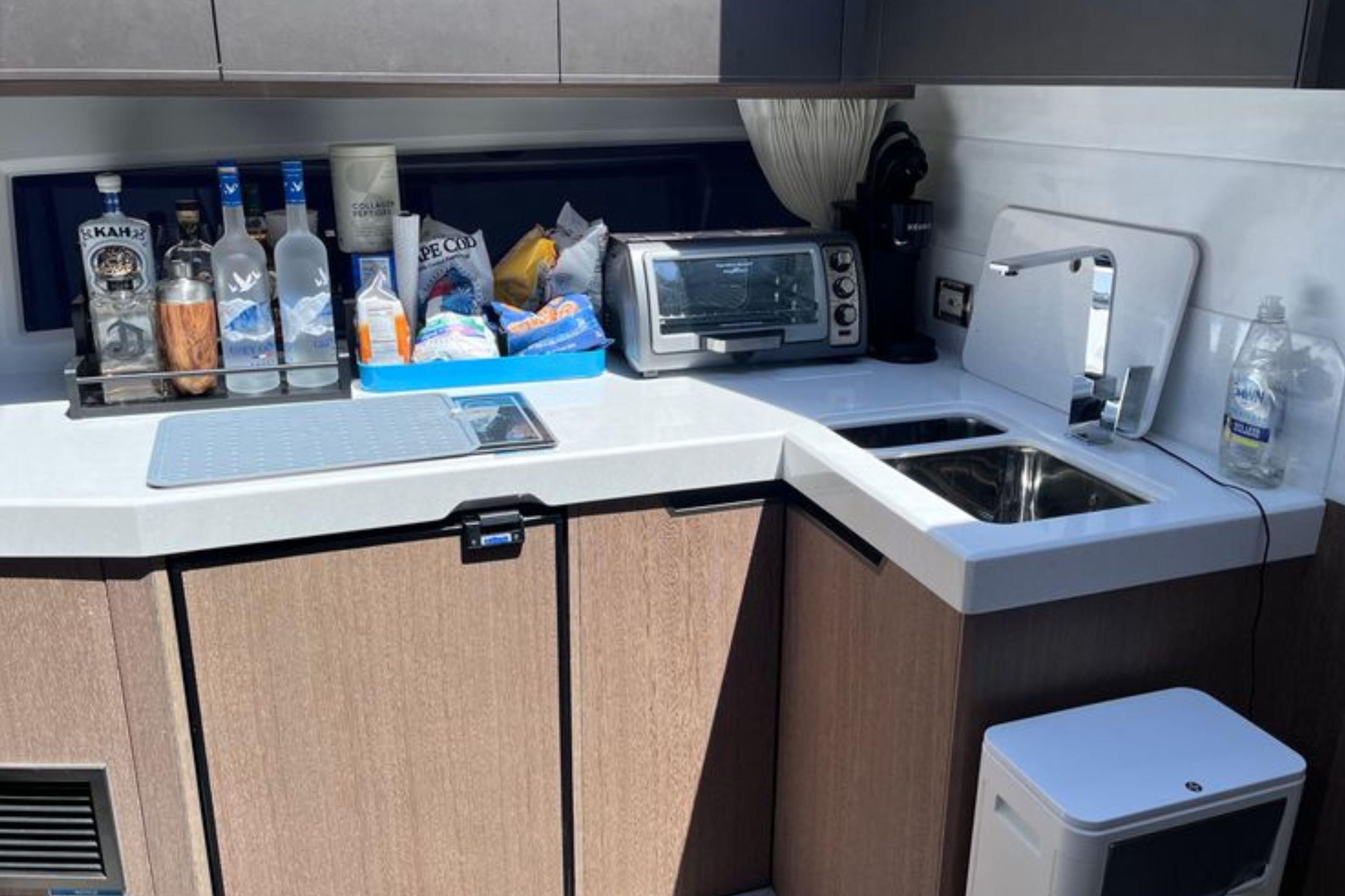 Kitchen area of 2024 Galeon 425 HTS yacht with sink, appliances, and beverages.