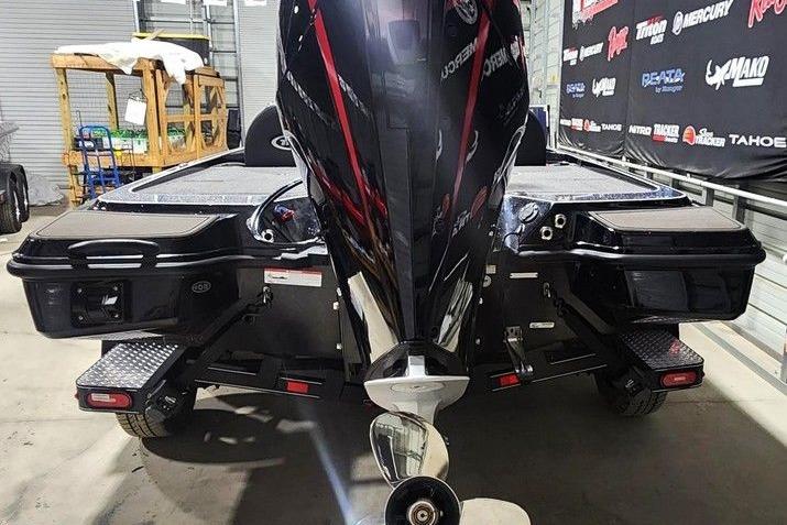 2026 Triton 20XP Patriot boat in showroom, rear view with motor and trailer.