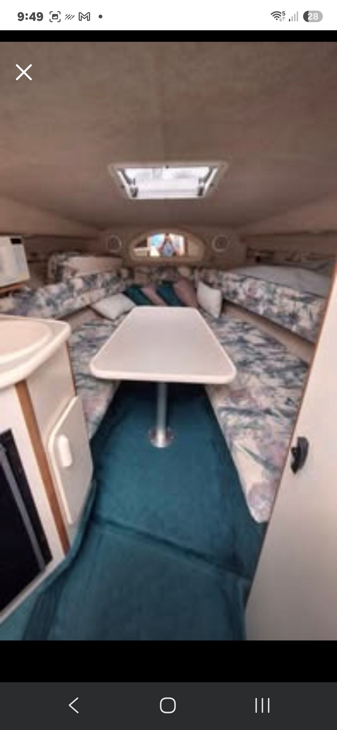 Interior of the 1998 Sea Ray 240 Sundancer with seating area and table.