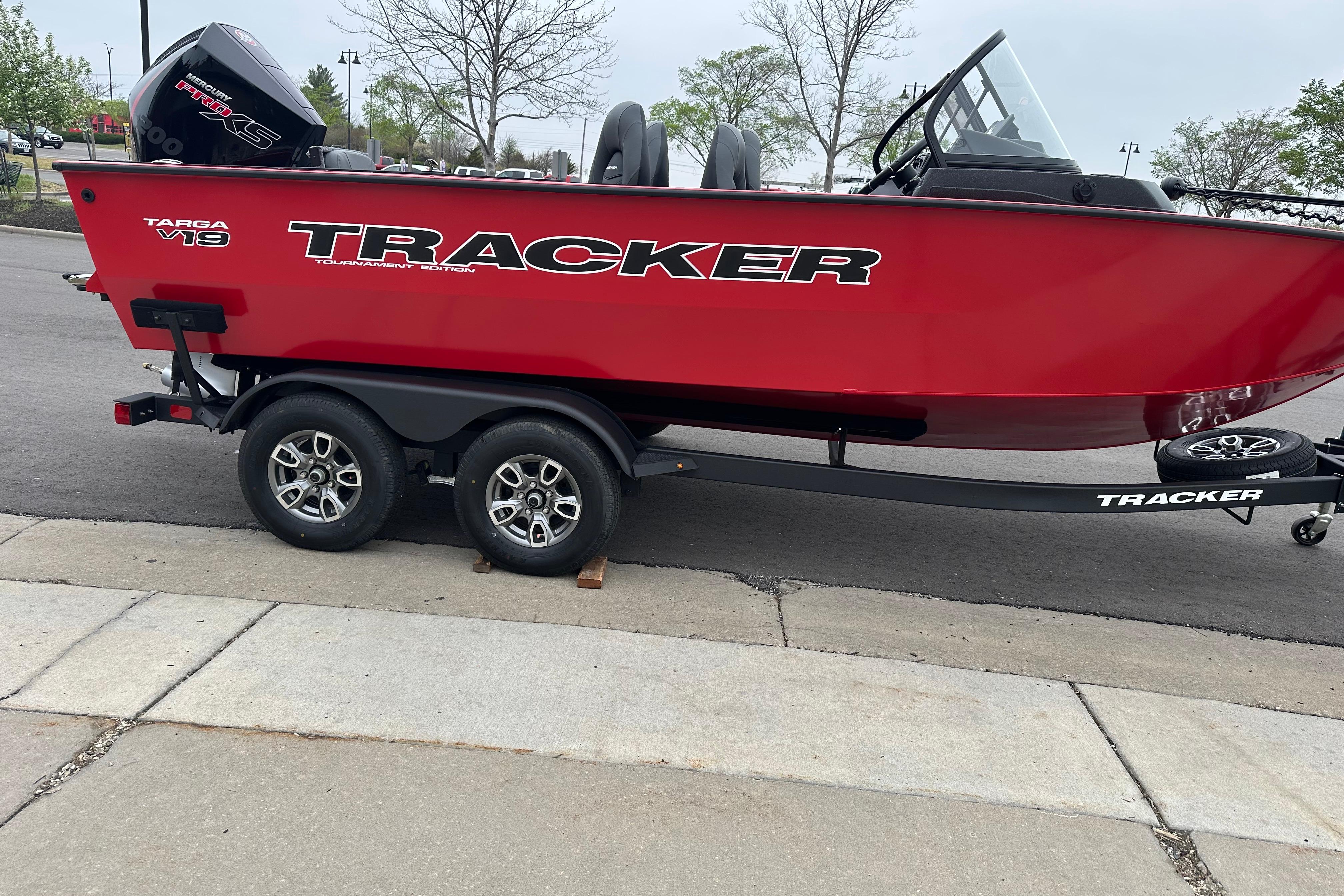 2026 Tracker Targa V-19 Combo boat on trailer, red exterior, parked on pavement.