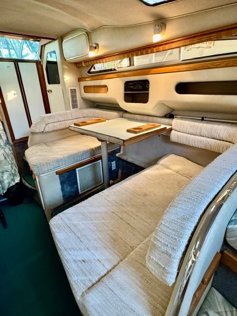 Interior of the 1992 Sea Ray 290 Sundancer with cozy seating and a table.