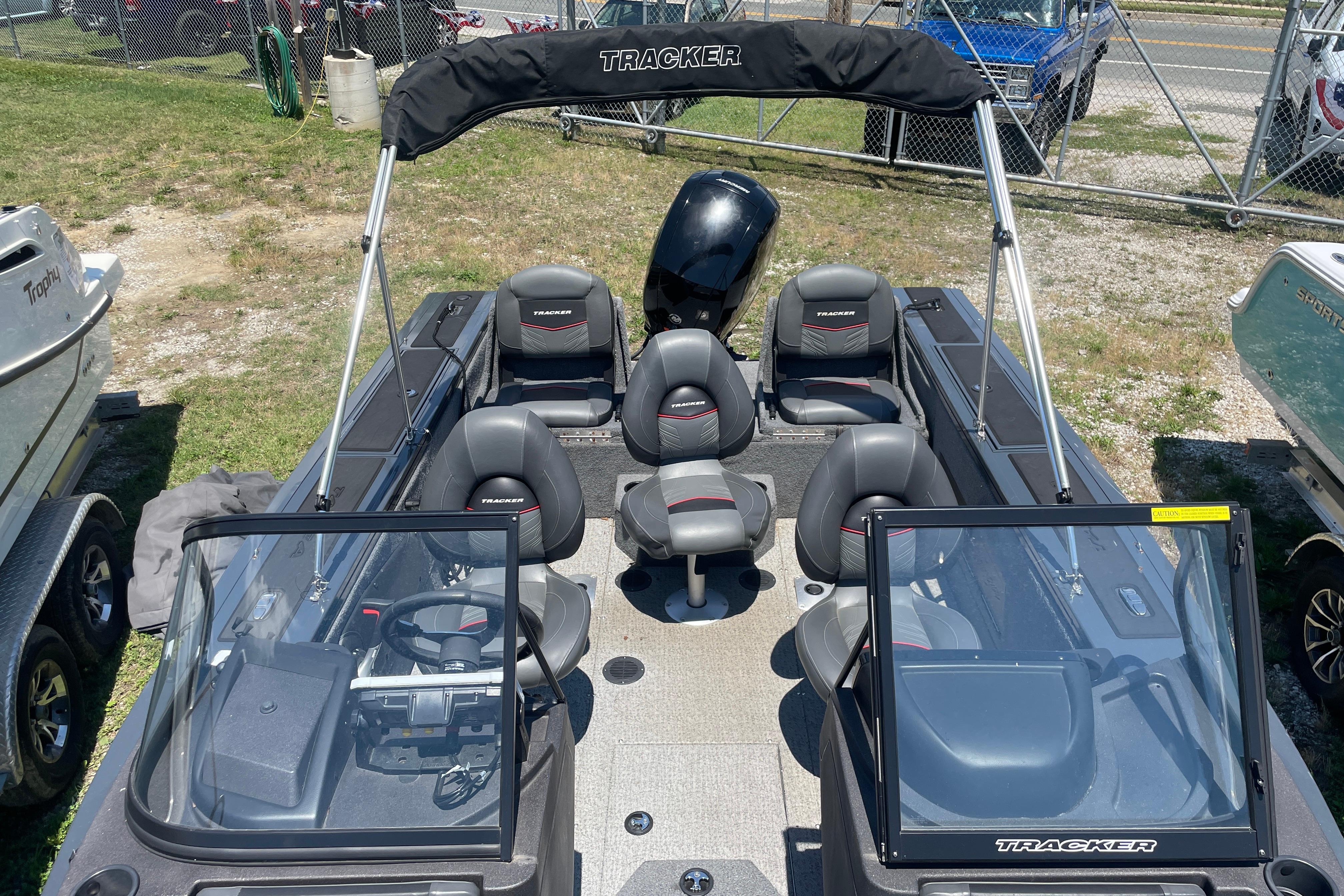 2022 Tracker Targa V-18 WT boat with seating and windshield, parked outdoors.
