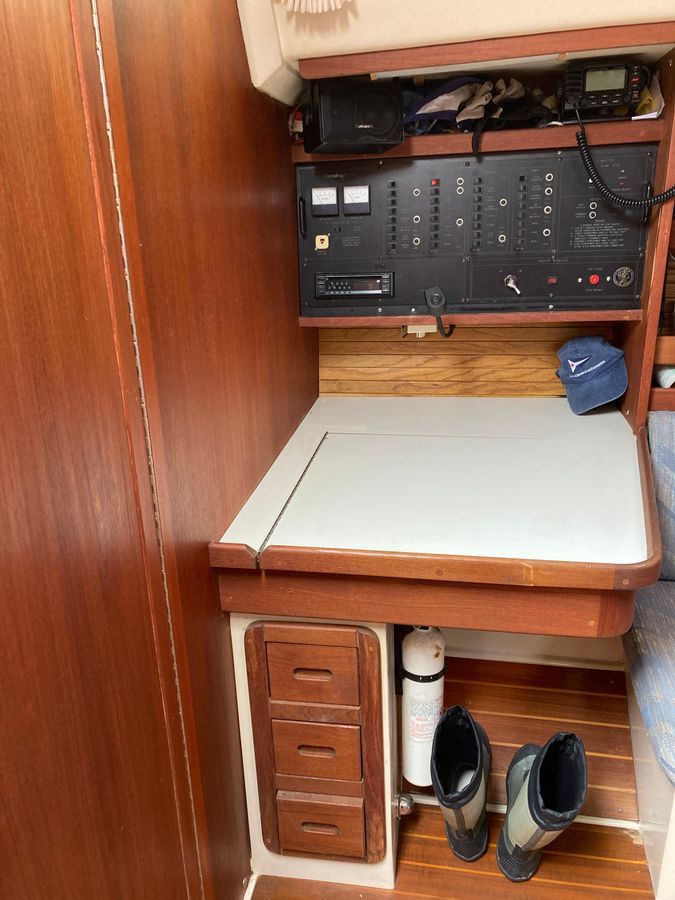 Interior of a 1990 Catalina 42 Tricabin with a navigation station and wooden cabinetry.