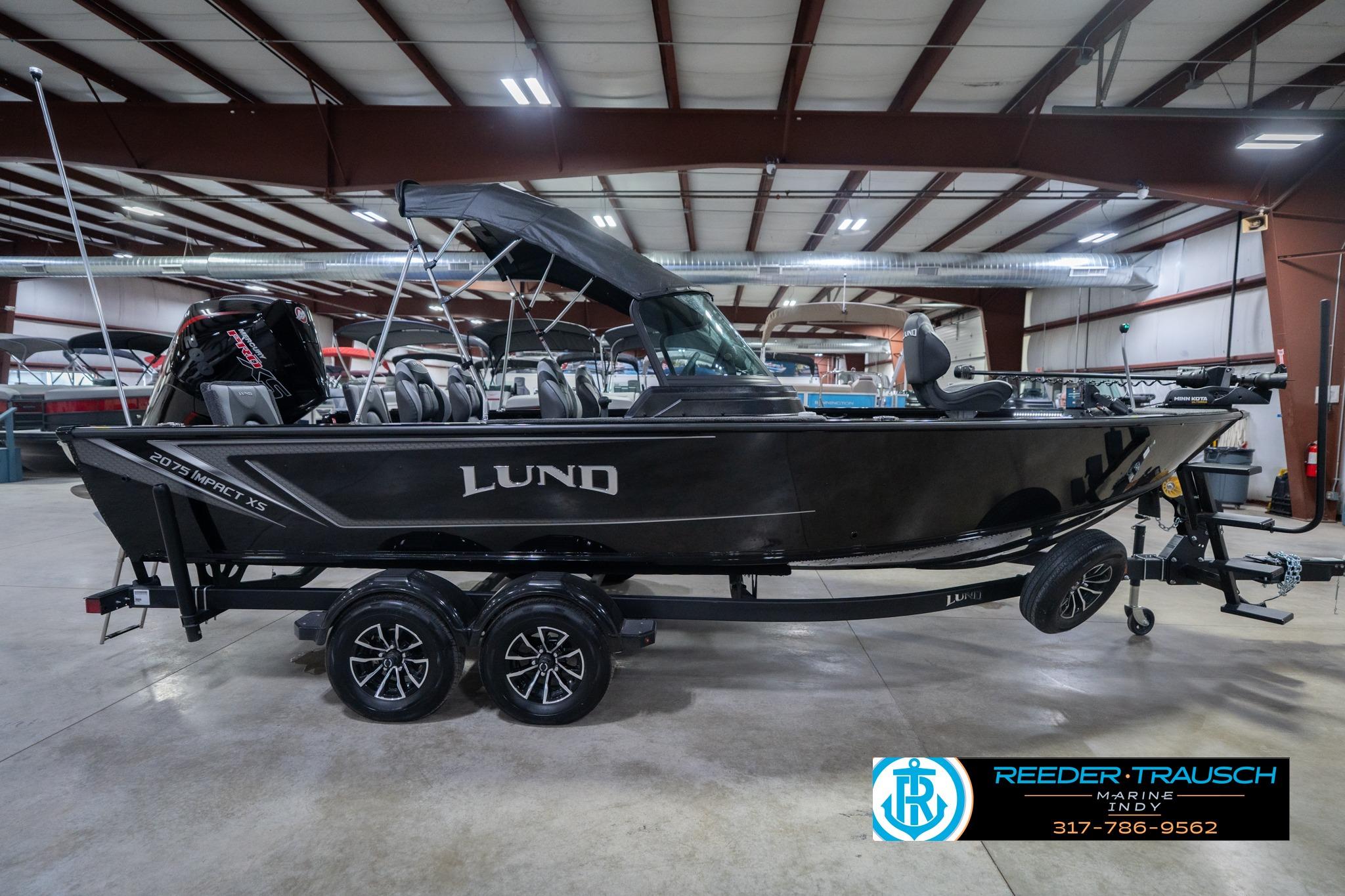 2026 Lund 2075 Impact XS boat in showroom, side view, on trailer.