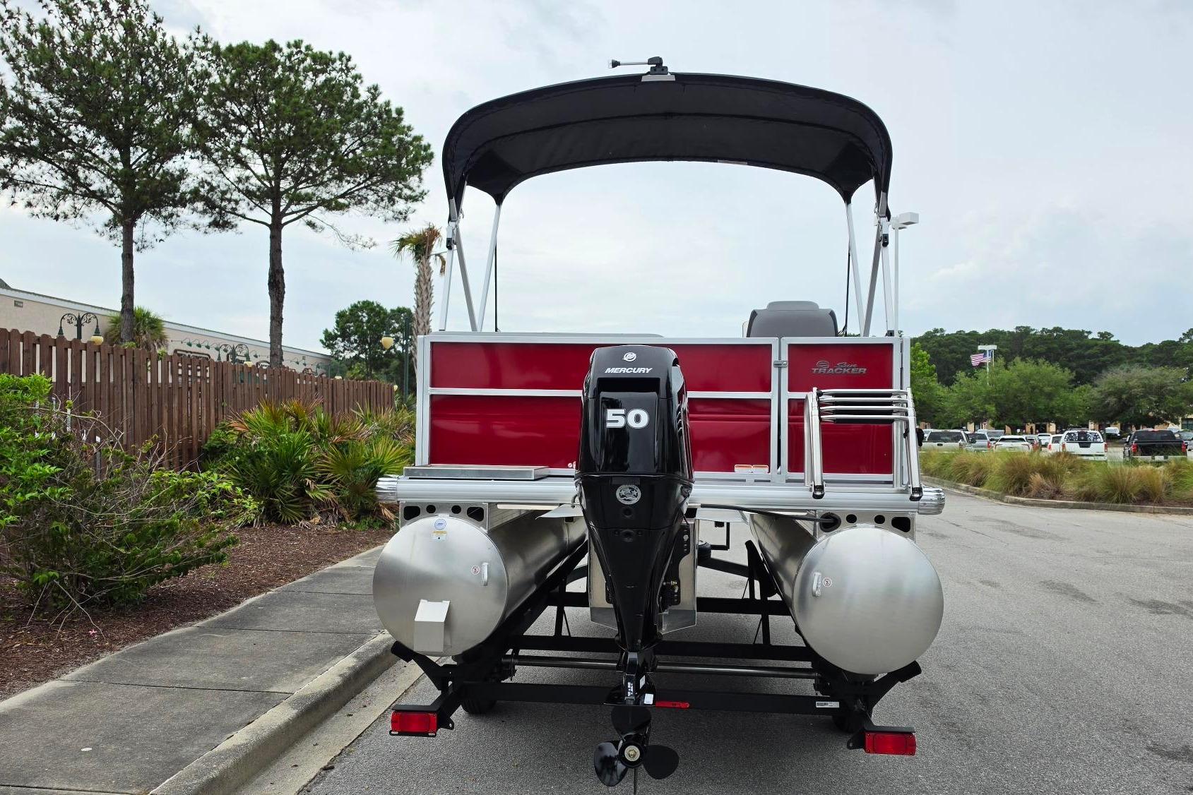 2026 Sun Tracker Party Barge 16 DLX pontoon boat with Mercury 50 engine, parked outdoors.
