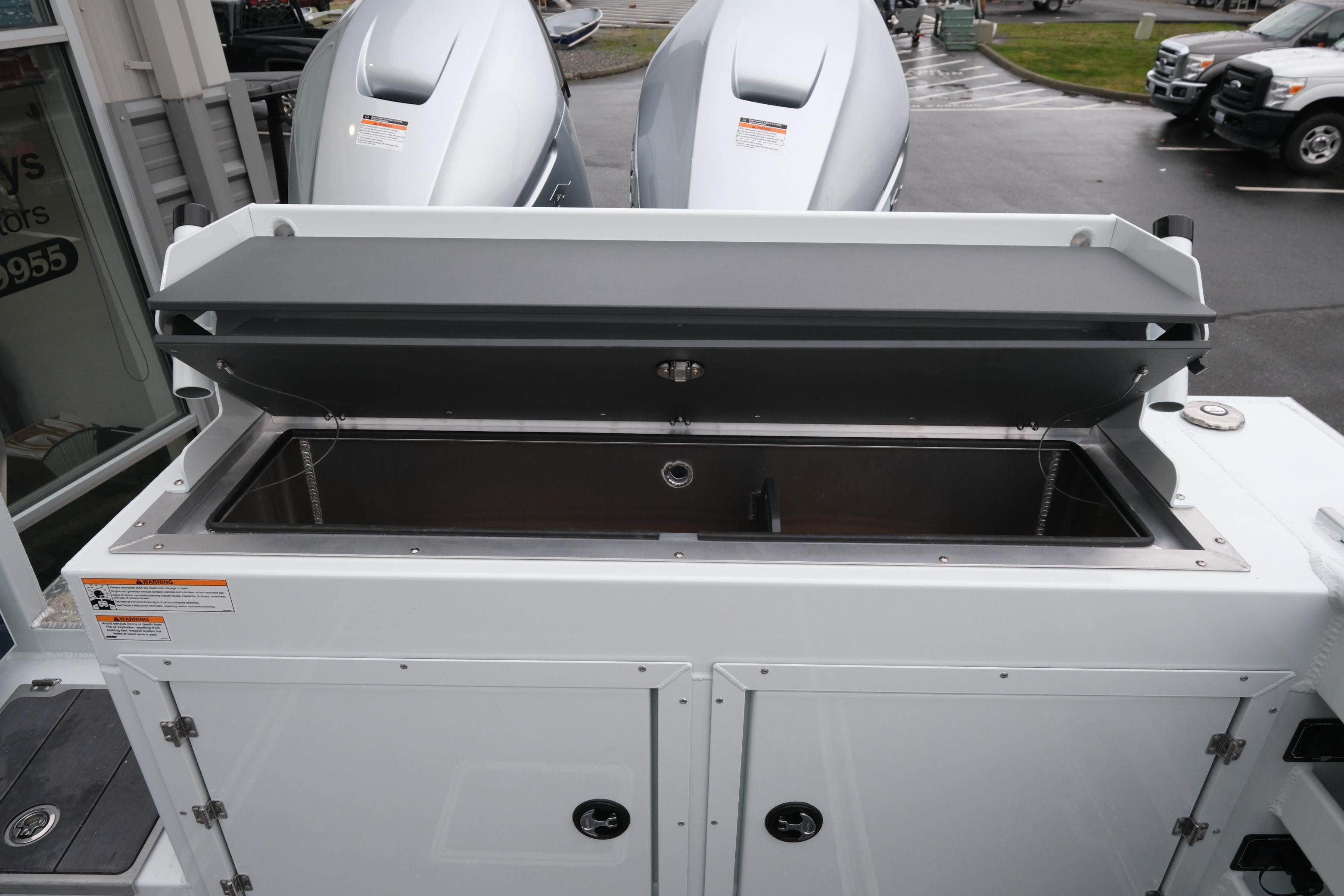2026 Hewescraft 270 Pacific Explorer boat with open storage compartment and dual engines.