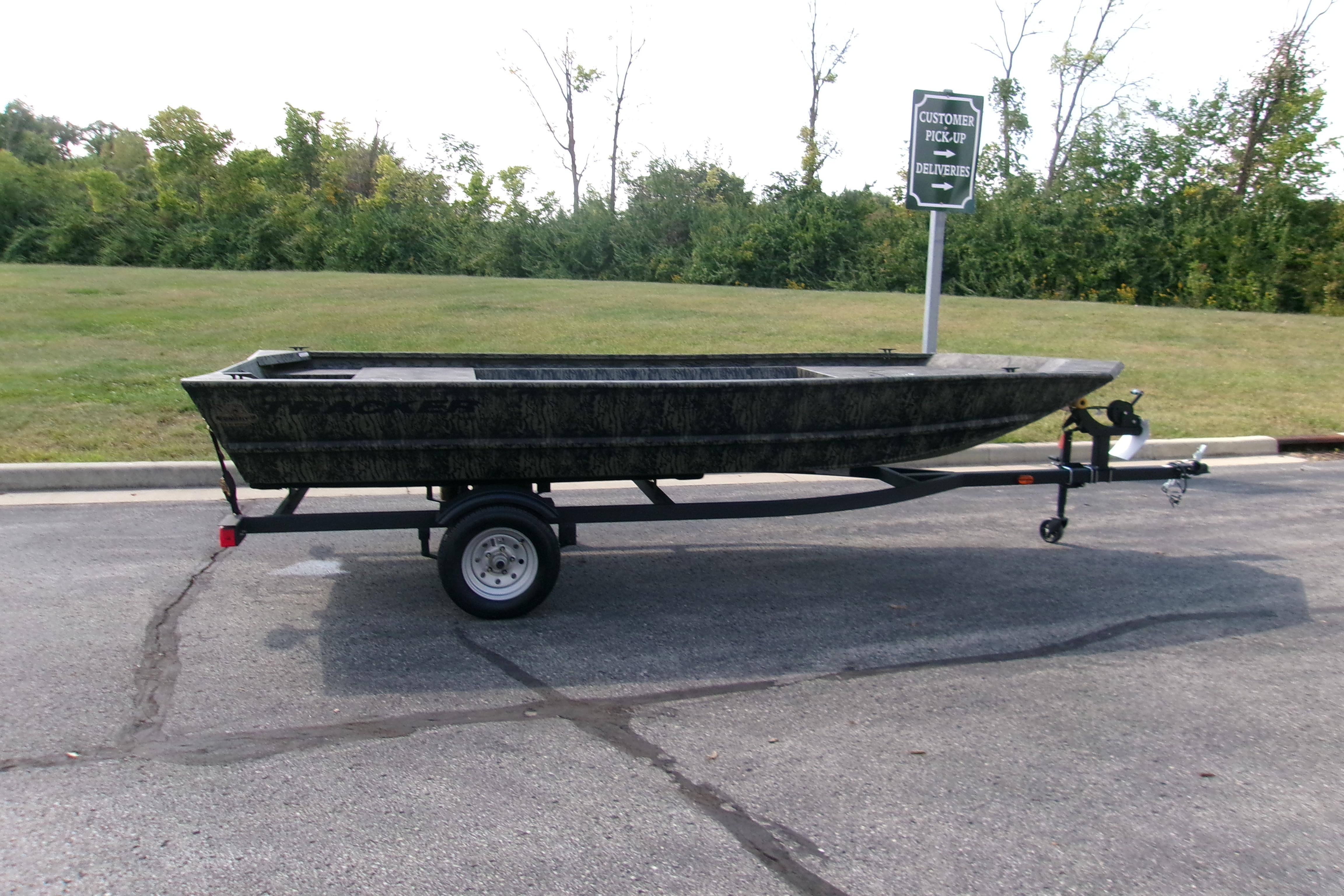 2026 Tracker Grizzly 1648 Utility boat on trailer in parking lot.