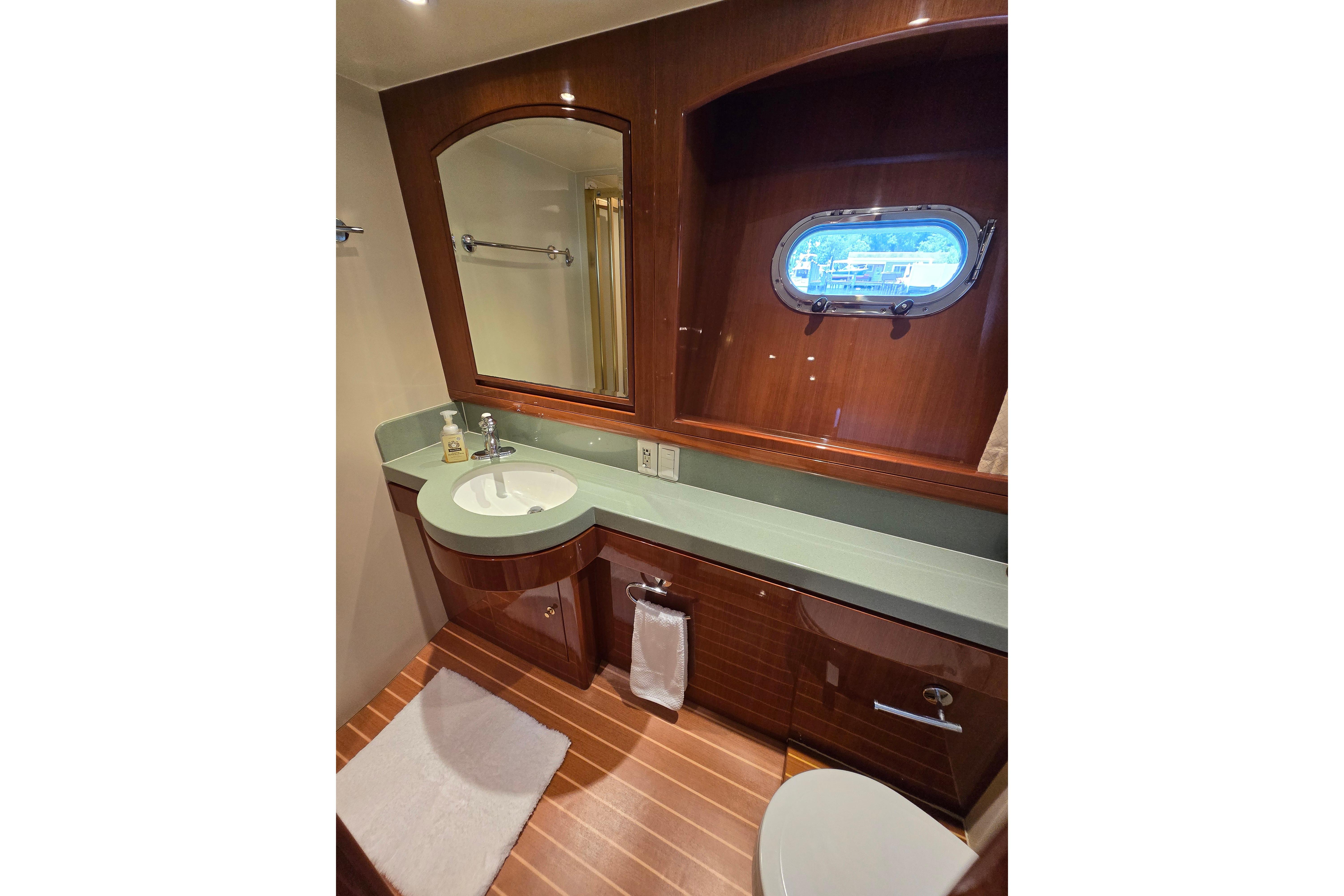 Luxurious 2004 Grand Harbour 58 yacht bathroom with wood accents and porthole window.