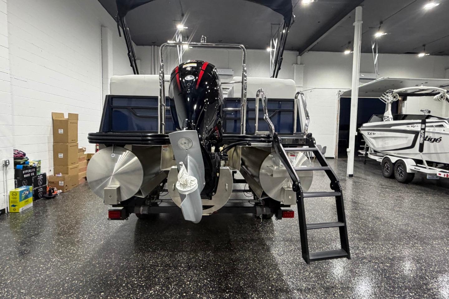 2026 Lowe SS 230 WT boat in showroom, rear view with motor and ladder.