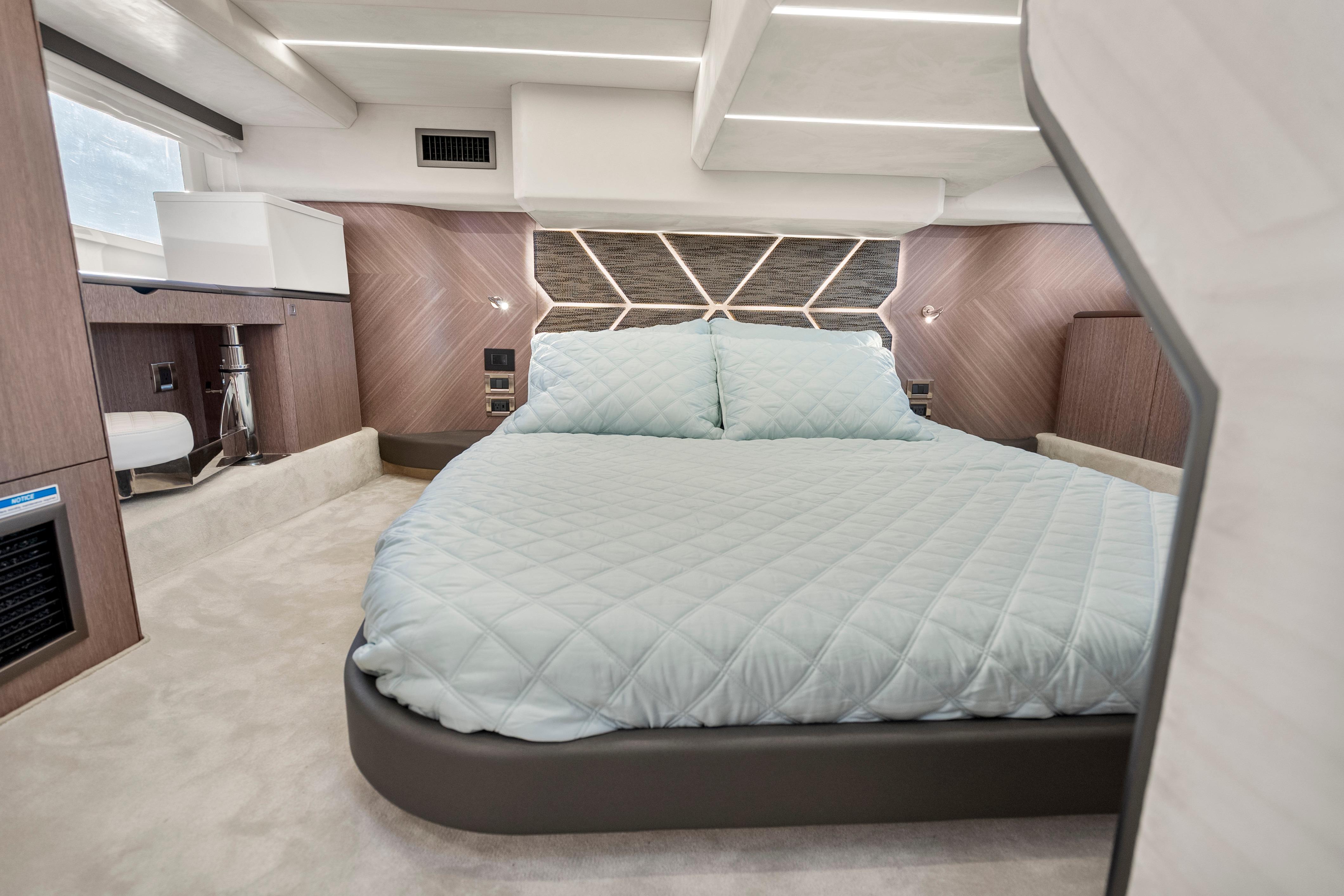 Luxurious bedroom interior of 2023 Galeon 400 Fly yacht with modern design and cozy bedding.