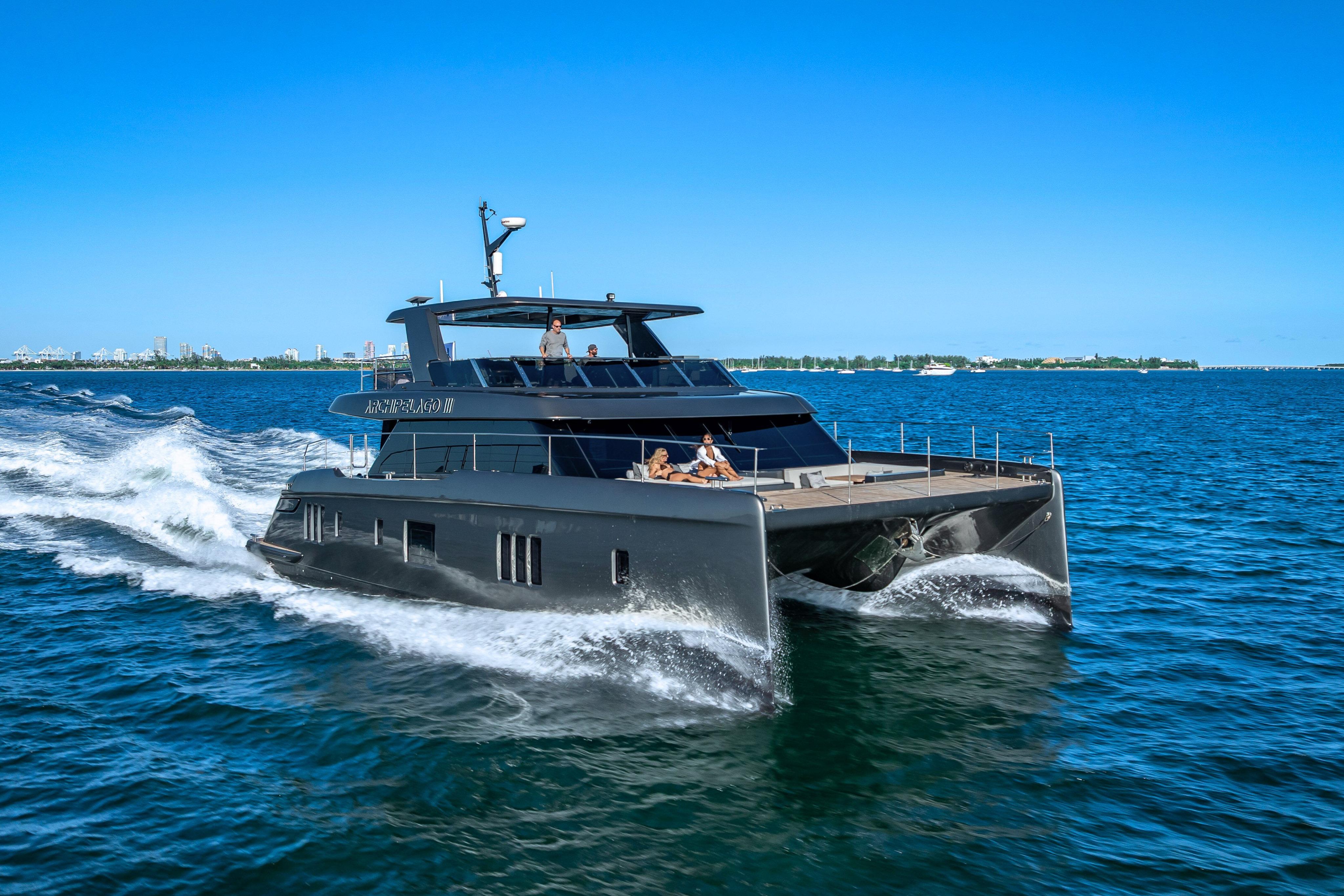 Luxurious 2026 Sunreef 60 Power yacht cruising on open water under clear blue skies.