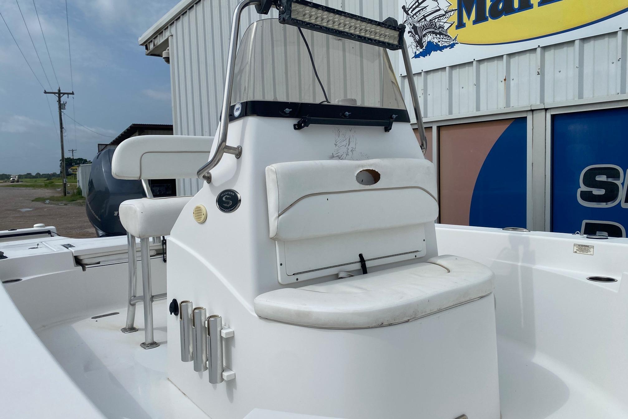 2013 Sportsman Masters 227 Bay Boat with seating and console, docked near a marina.