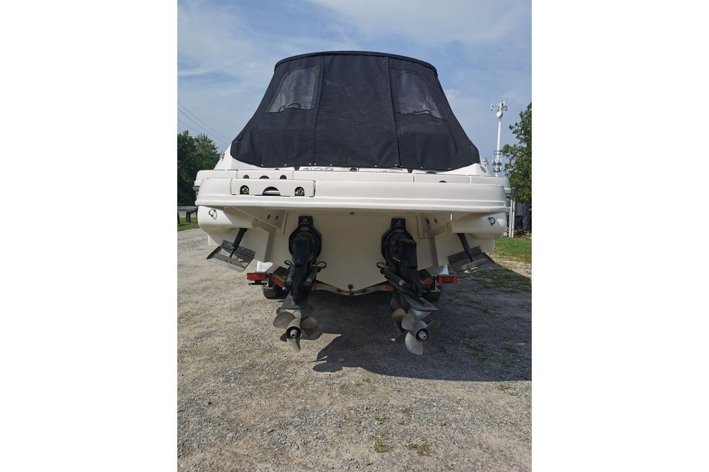 Rear view of a 2012 Sea Ray 300 SLX boat with dual propellers and black cover.