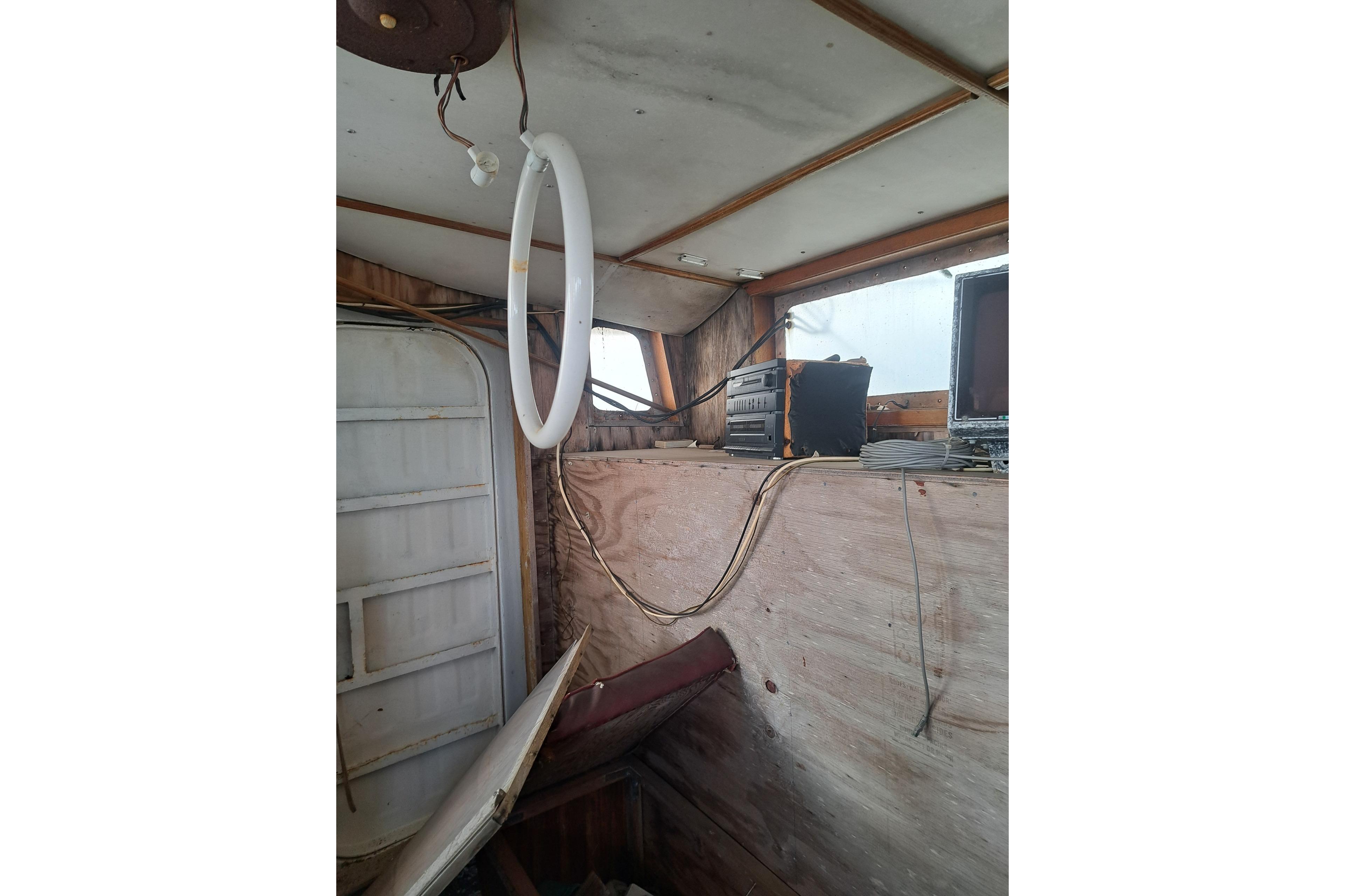 Interior of a 1979 Custom Steel Trawler Dragger with vintage equipment and wooden paneling.