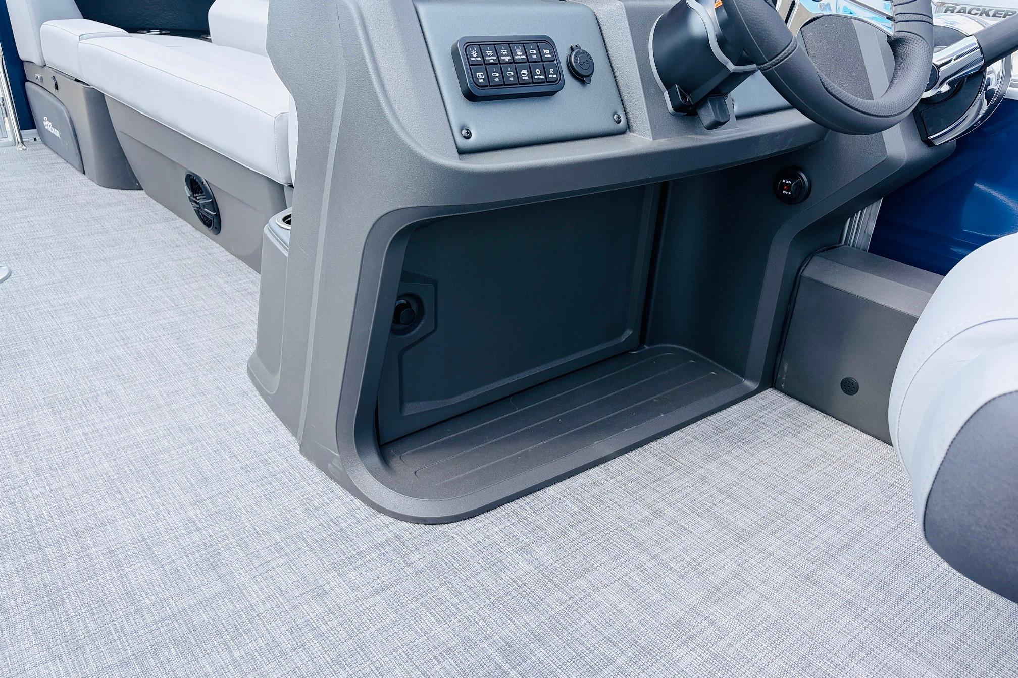 Interior view of 2026 Sun Tracker SportFish 22 DLX boat, featuring steering console and seating.