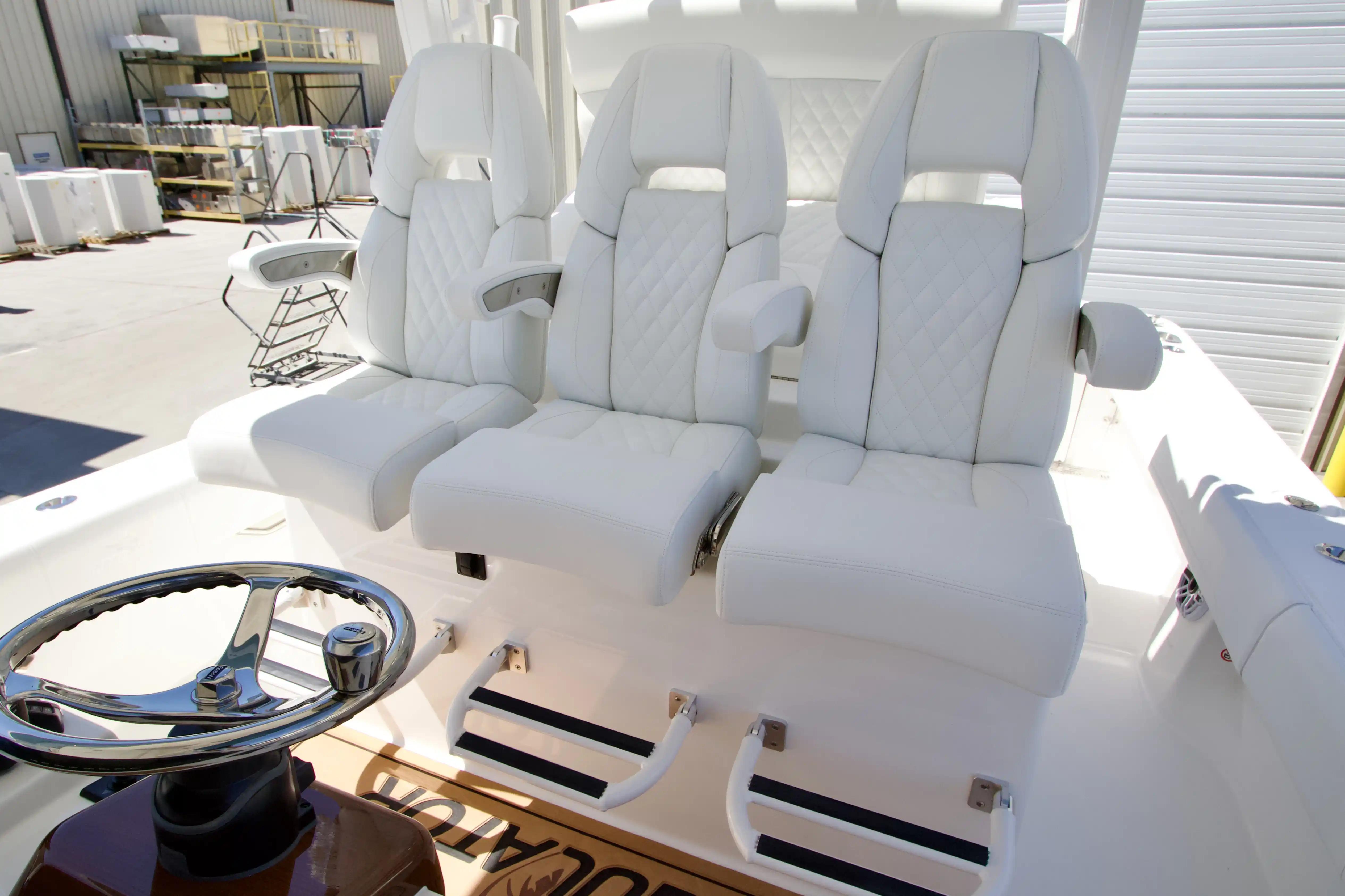 Luxury seating on 2027 Regulator 35 boat with white leather upholstery and steering wheel.