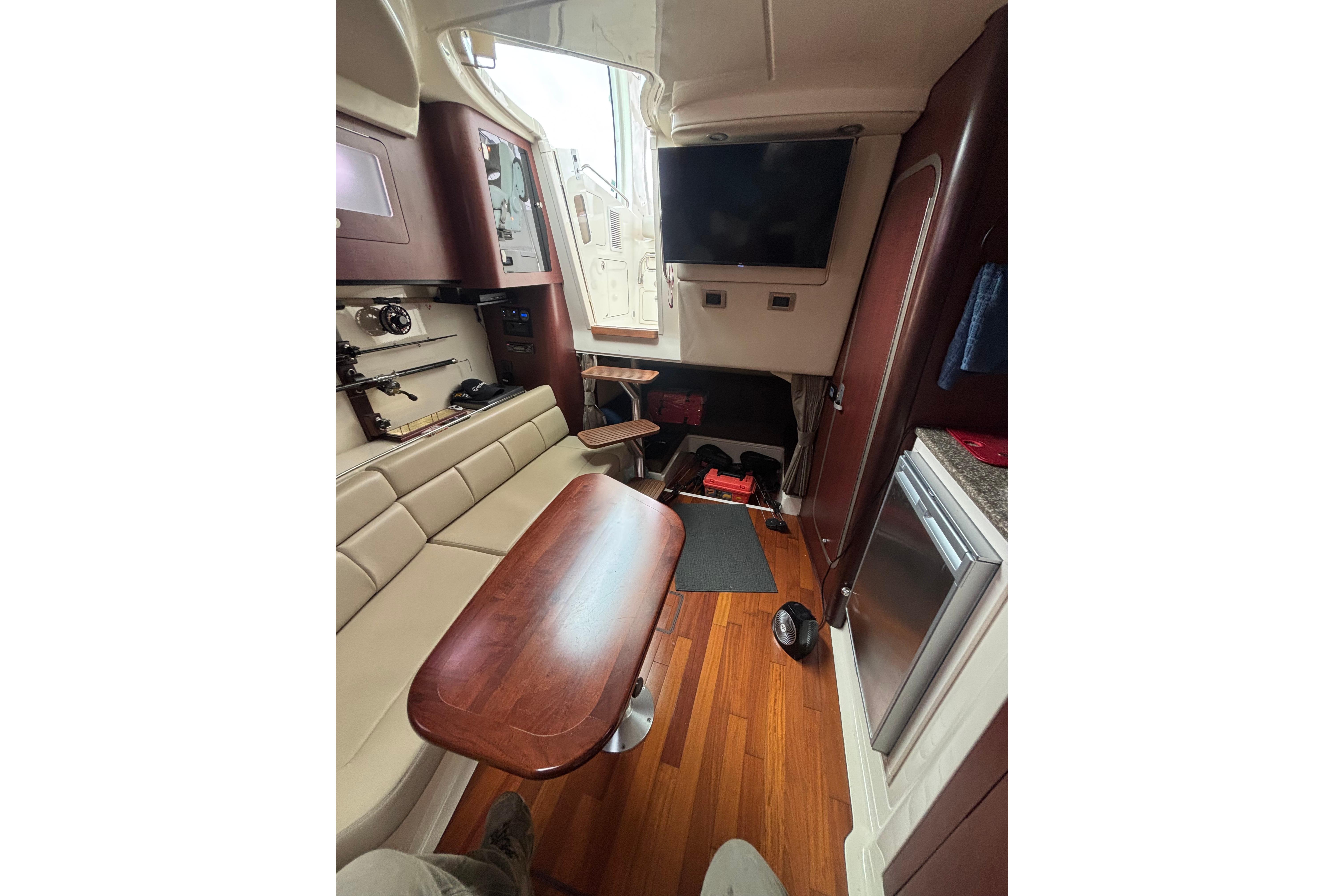 Interior of 2010 Boston Whaler 345 Conquest with seating, table, and TV.