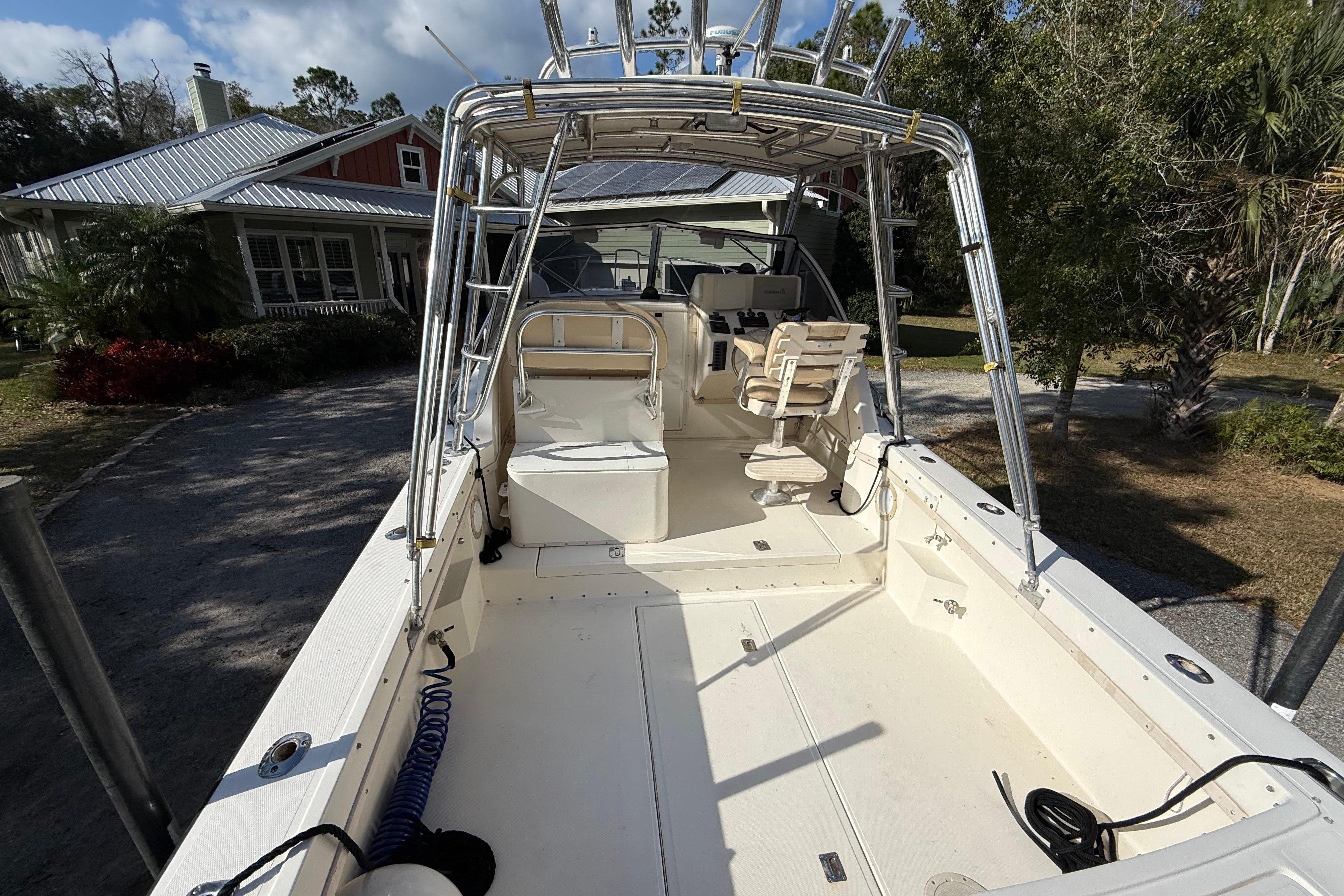 2002 Albemarle 265 Express Fisherman boat with spacious deck and seating, parked outdoors.