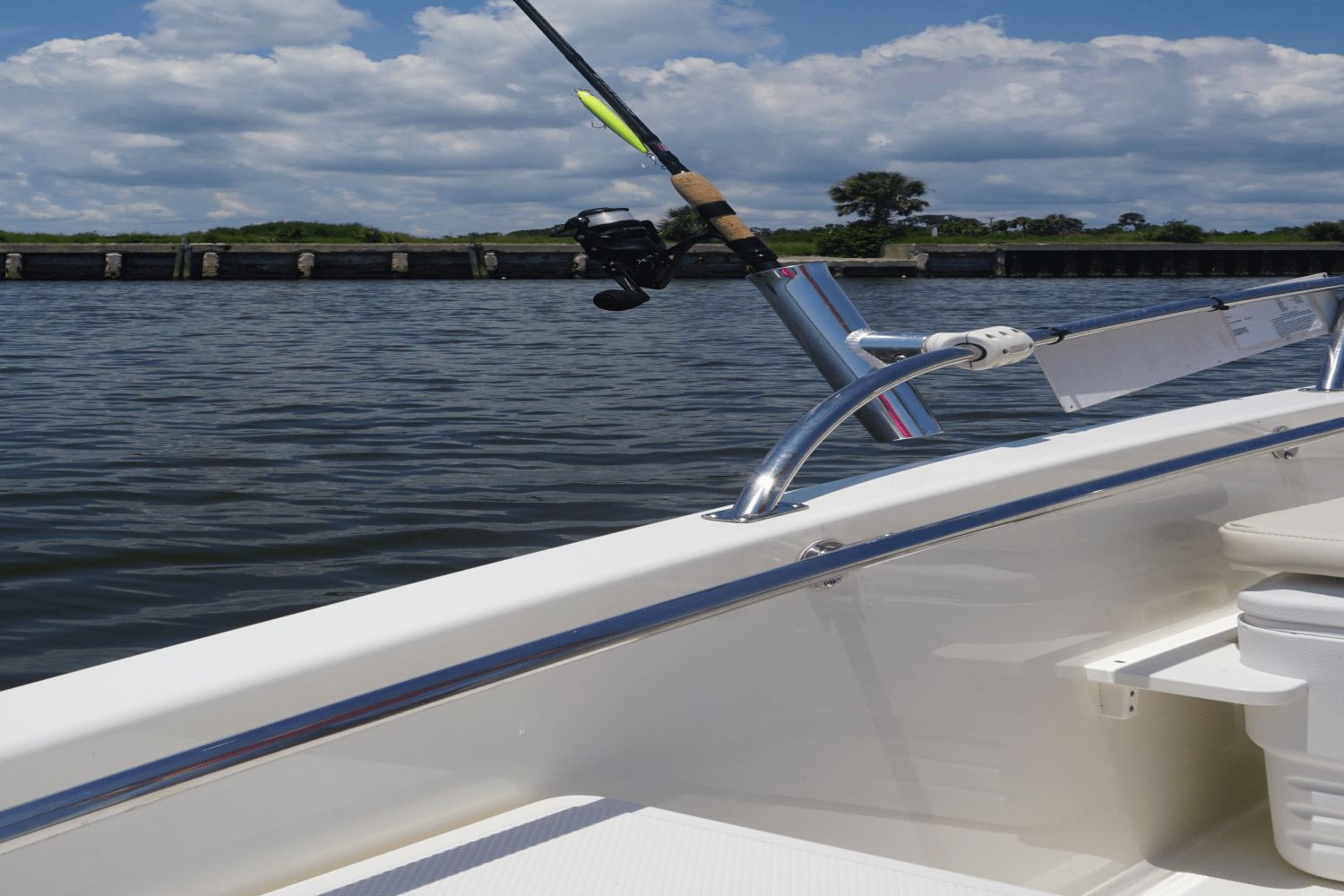A fishing rod holder on a Boston Whaler 130 Super Sport boat on calm water.