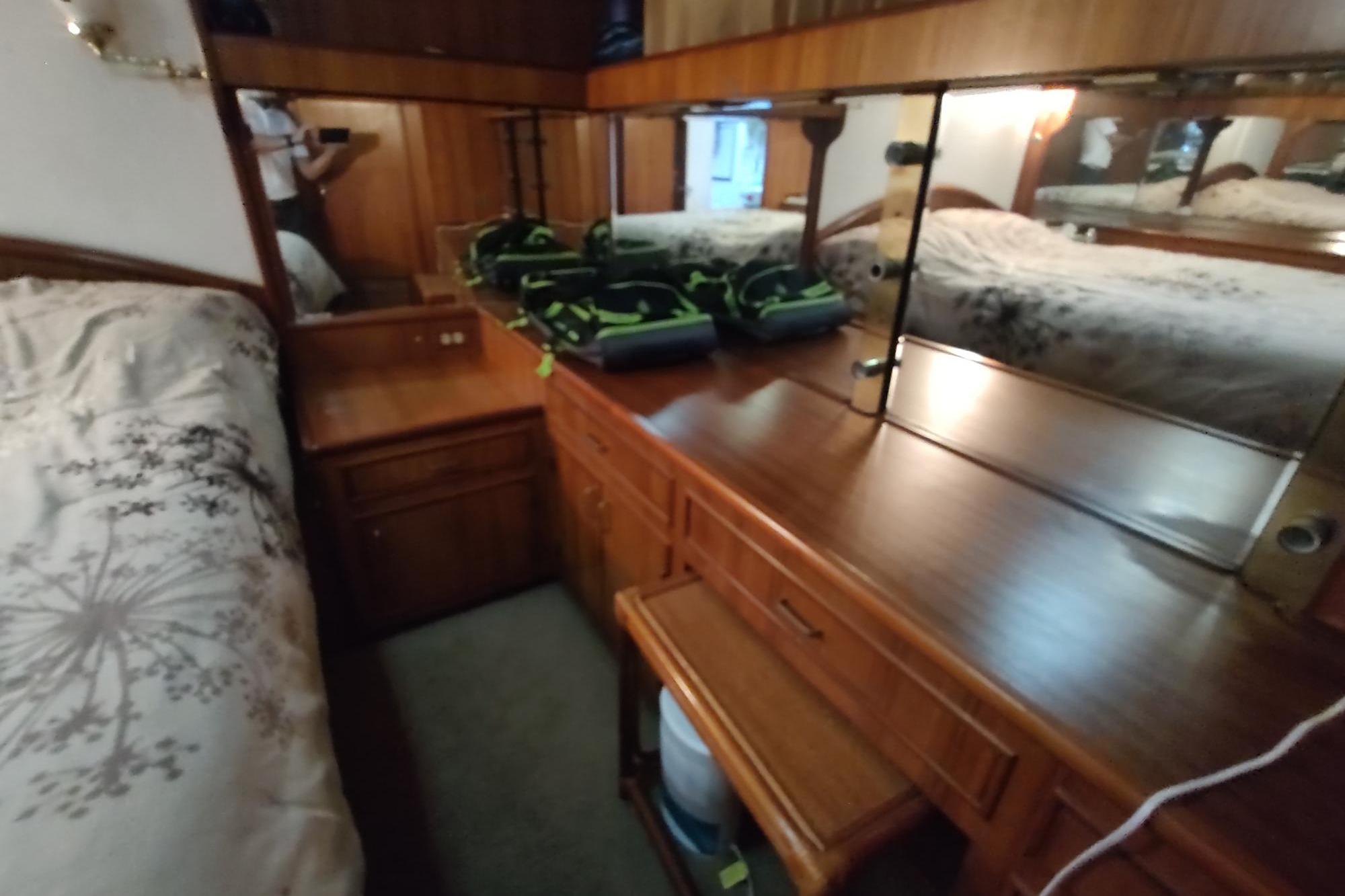 1989 Hyatt Double Cabin Motoryacht interior with wooden cabinetry and mirrored dresser.