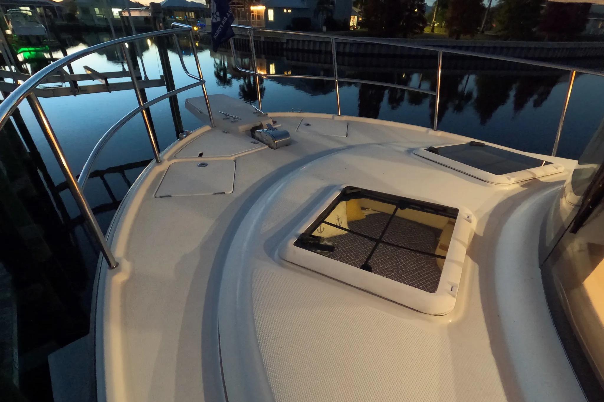Bow view of 2015 Ranger Tugs R-29 S boat at dusk, featuring deck and hatch.