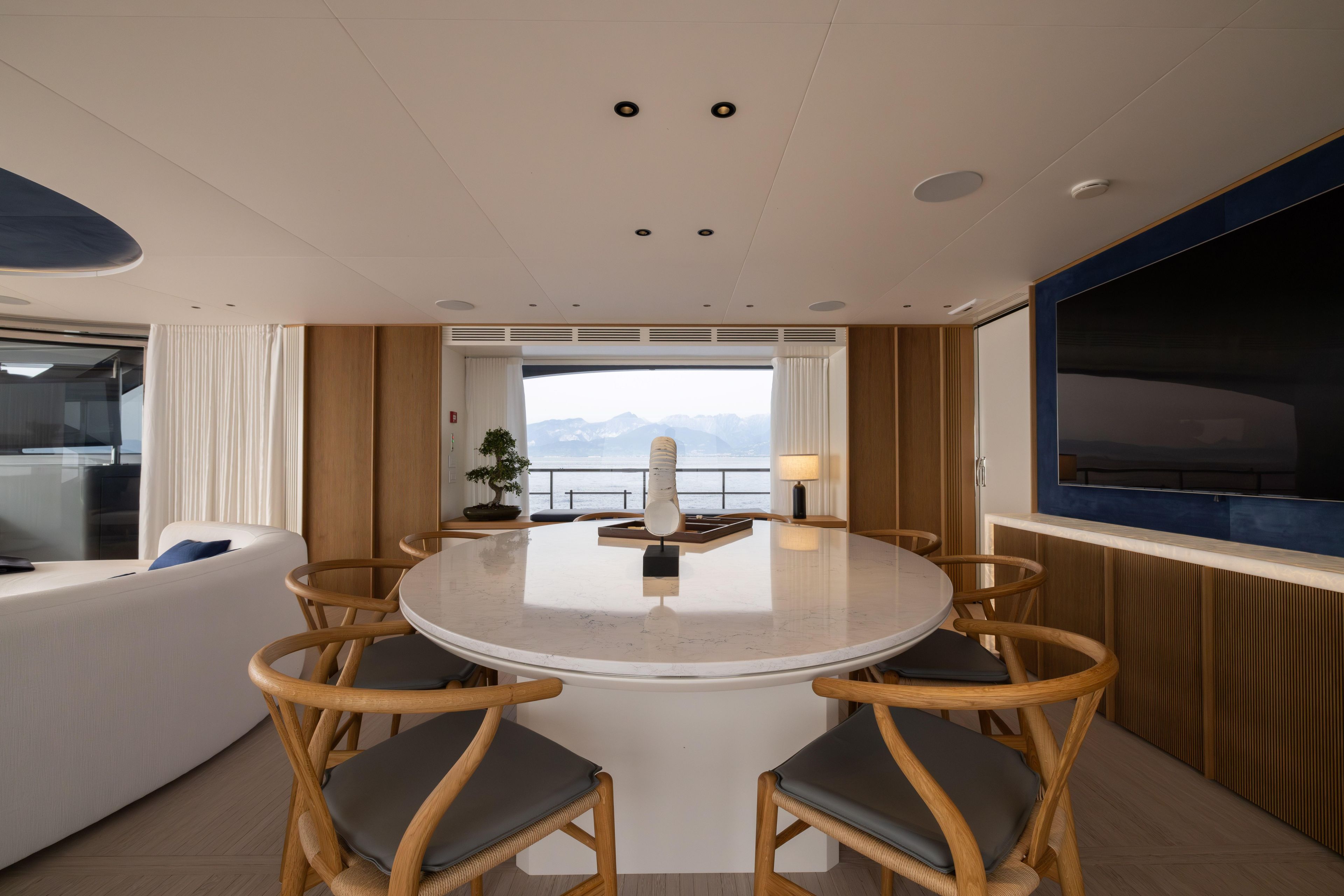 Luxurious interior of 2024 Benetti Oasis 34M yacht with elegant dining area and sea view.