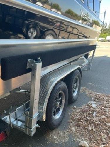 2025 Spartan 2600 Olympia boat trailer with dual wheels, parked on a sunny day.