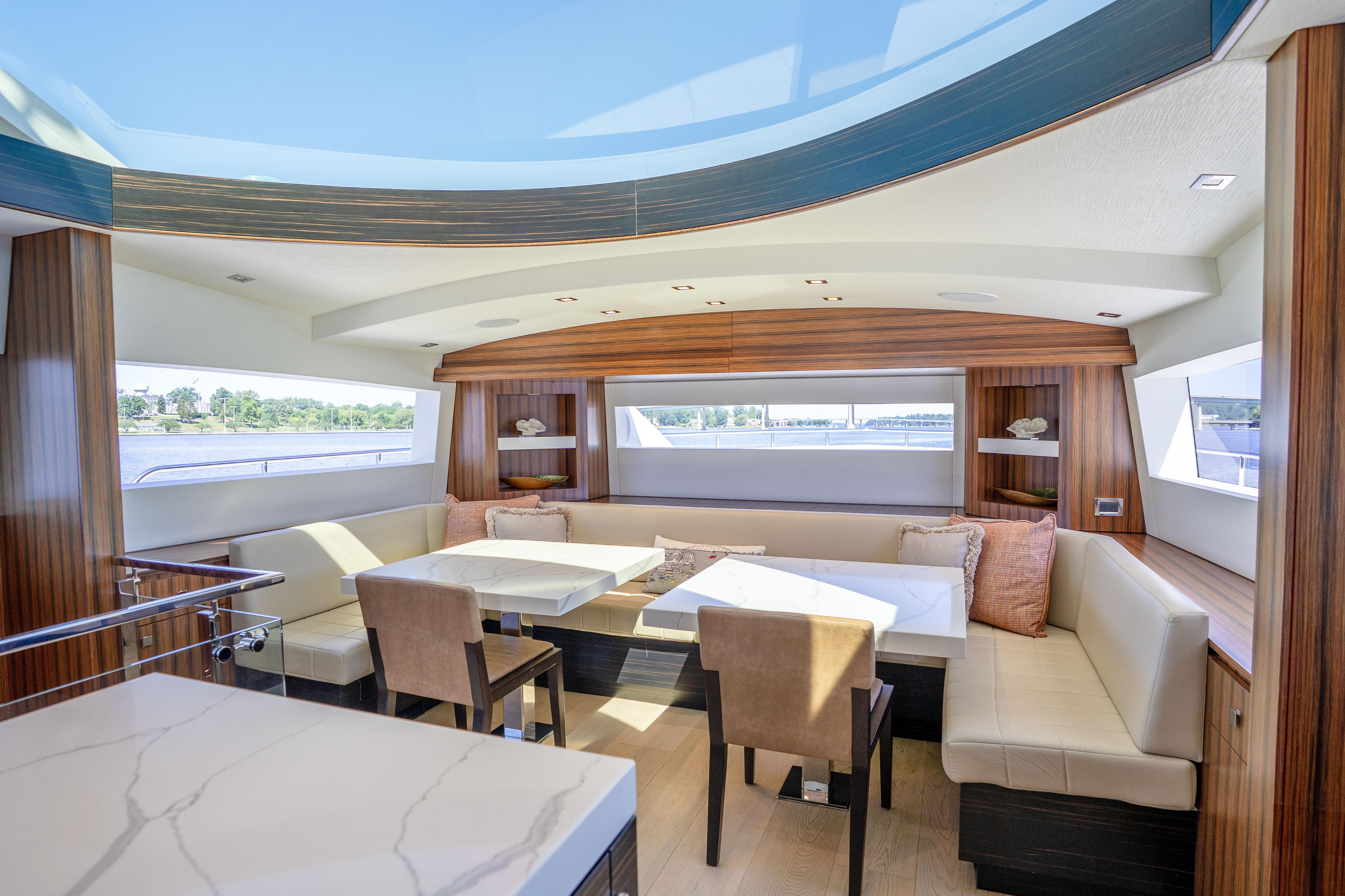 Luxurious interior of 2021 Hatteras M75 Panacera yacht with elegant seating and panoramic windows.