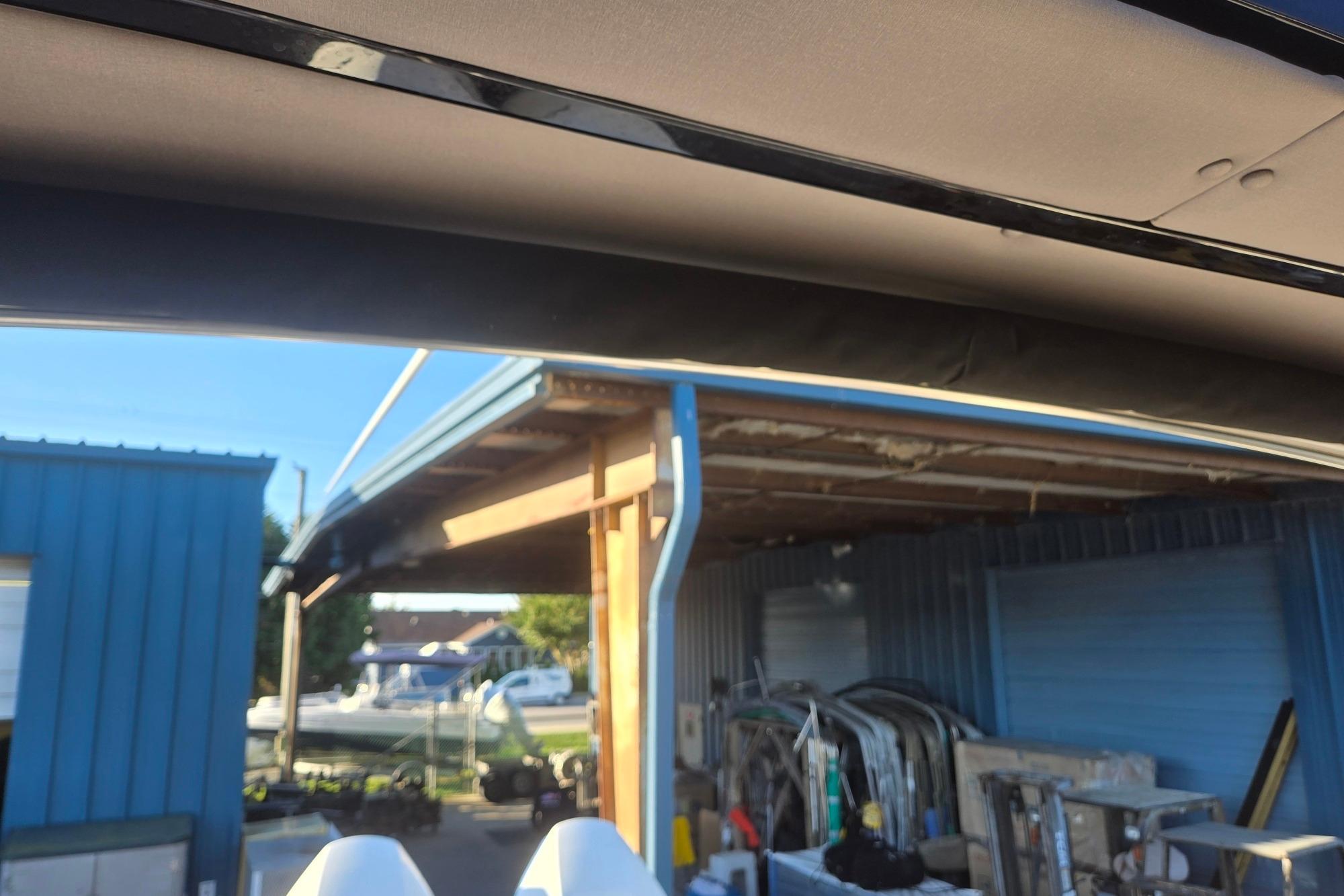Outdoor view of a 2026 Hurricane SunDeck 3200 OB near a blue storage building.