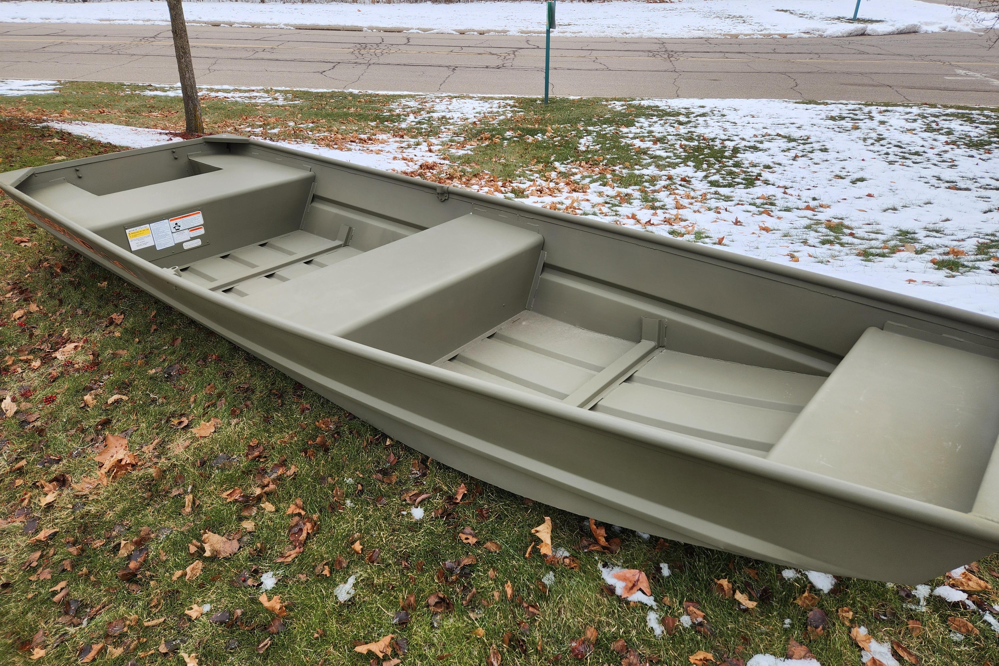 2026 Tracker Grizzly 14 Jon boat on grass with snow patches.