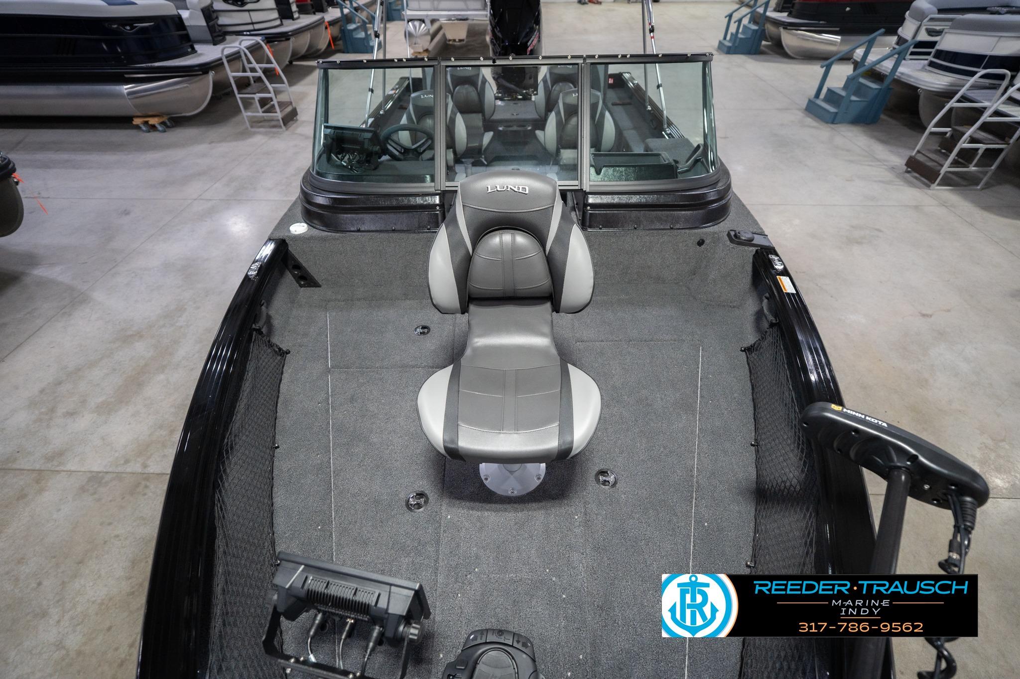 2026 Lund 2075 Impact XS boat interior with seating and windshield in showroom.