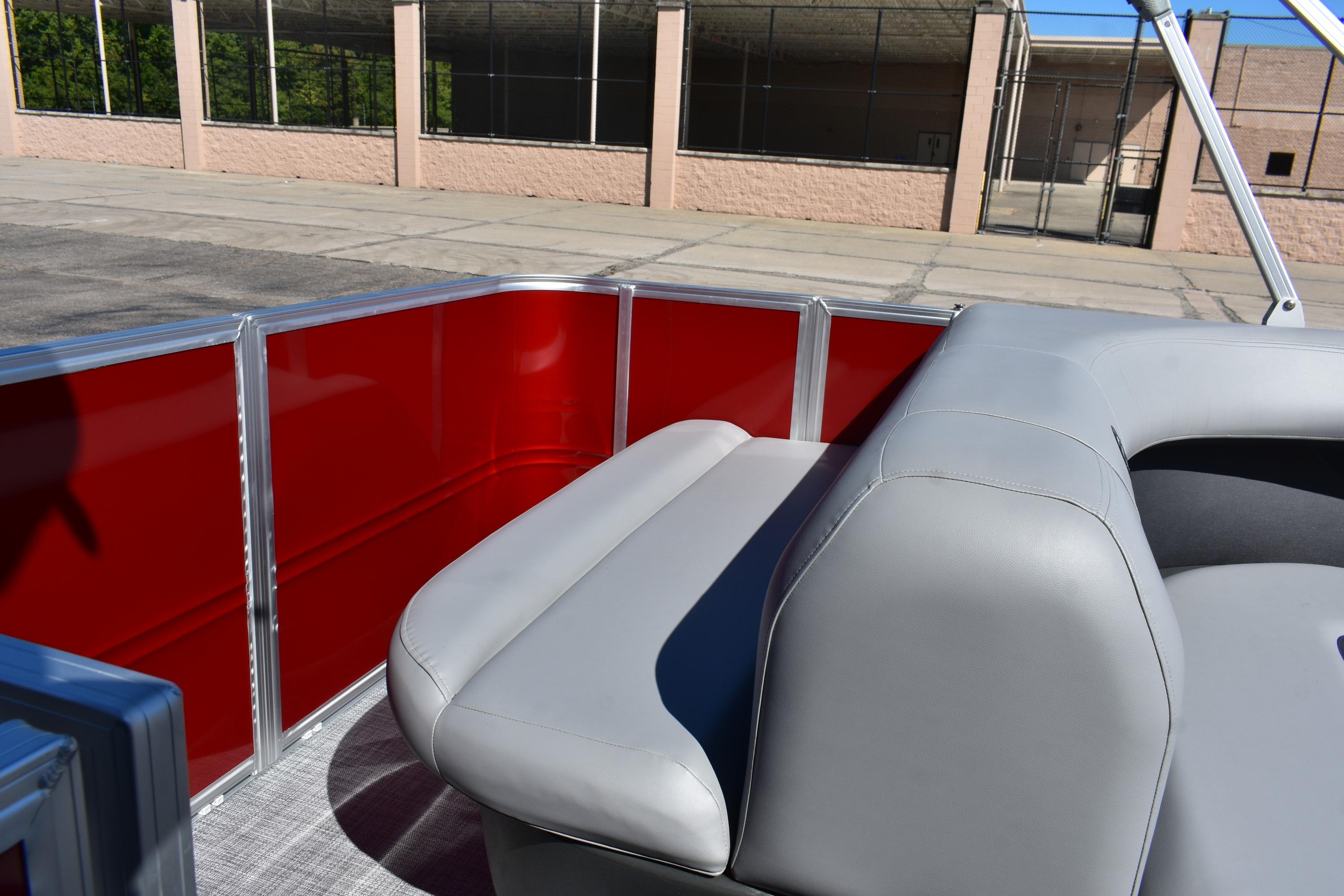 2026 Sun Tracker Party Barge 18 DLX with red paneling and gray seating.