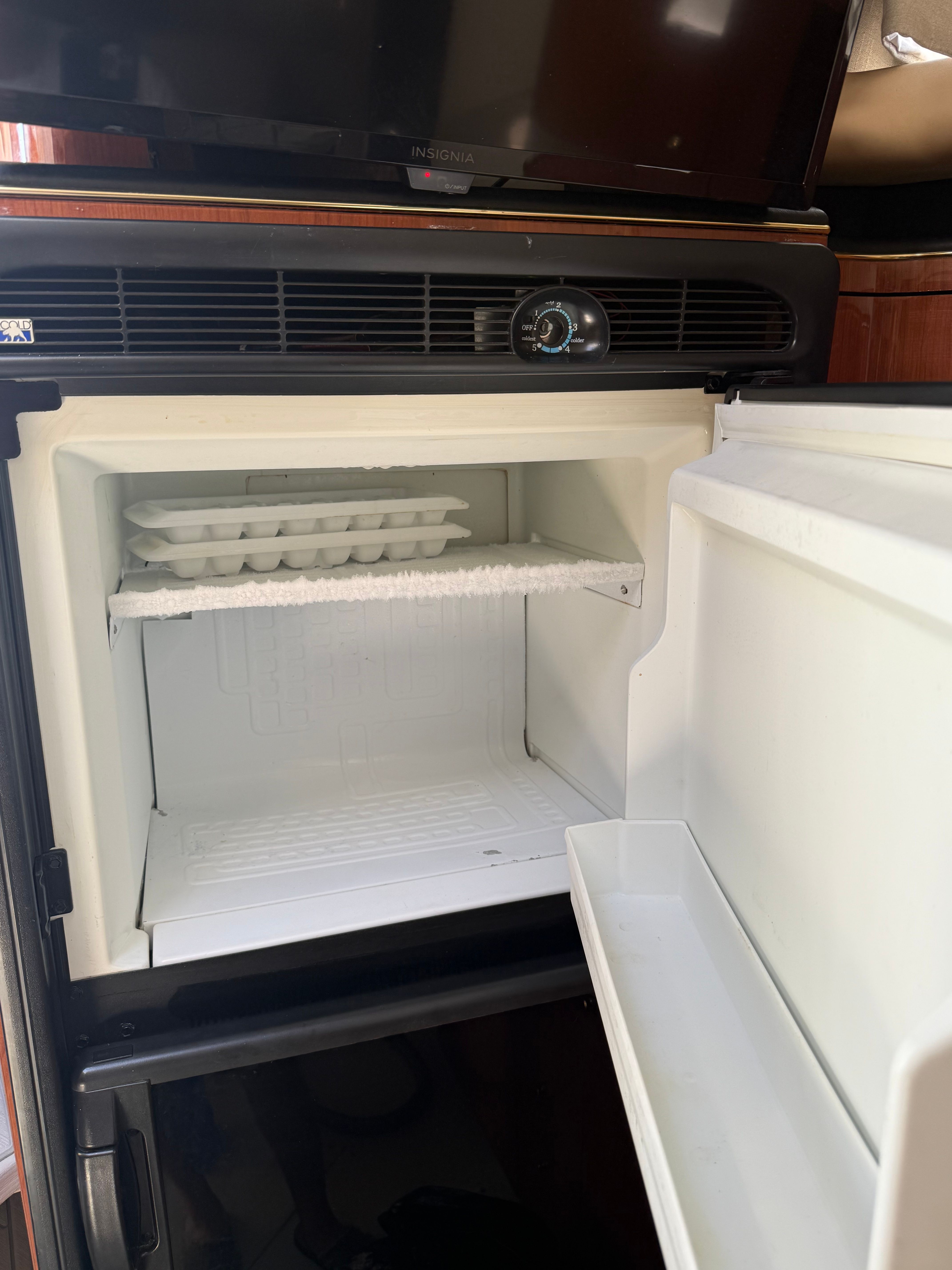 An open refrigerator with an ice cube tray inside.
