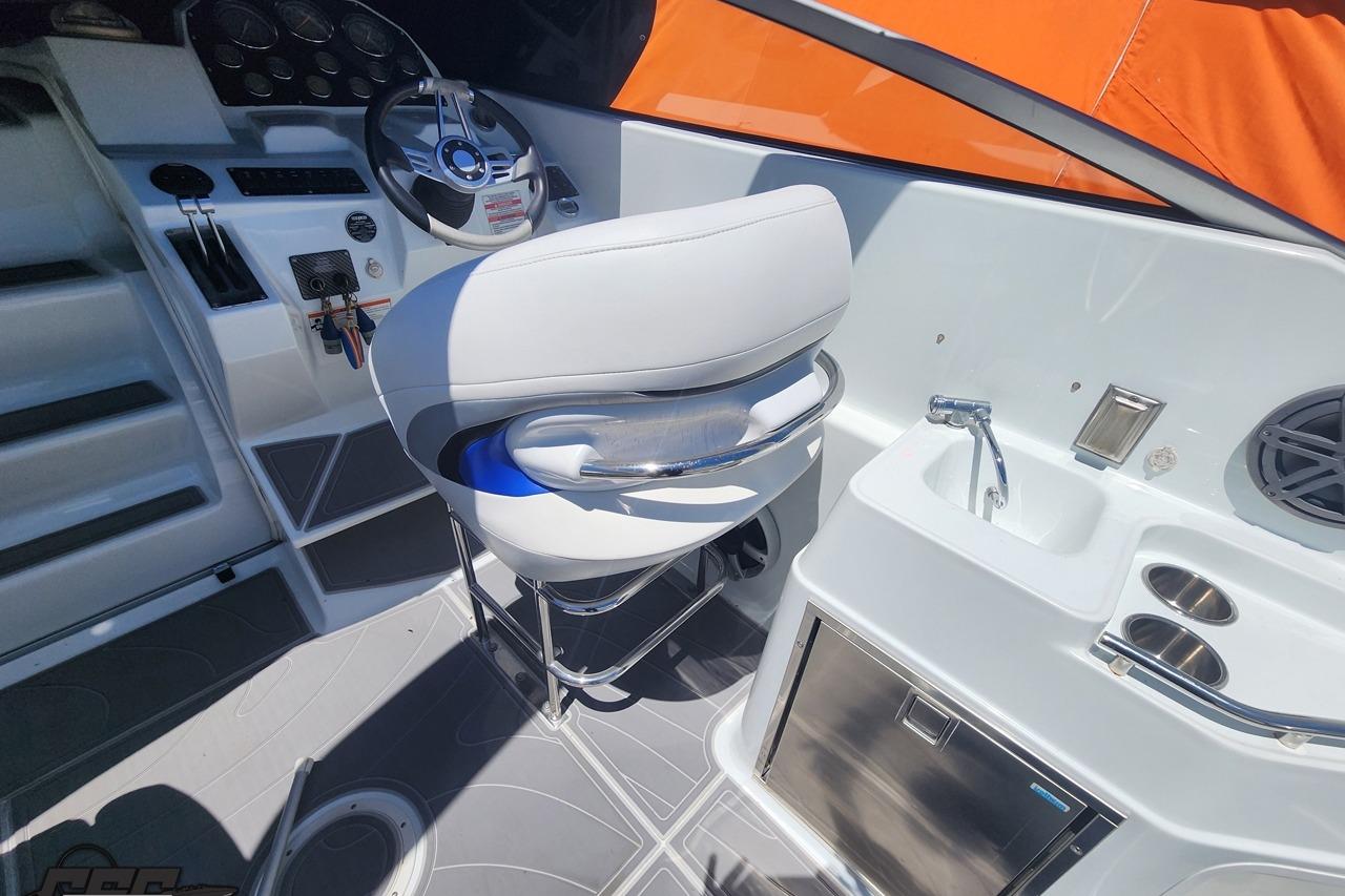 2008 Baja 335 Performance boat cockpit with steering wheel, seat, and sink.