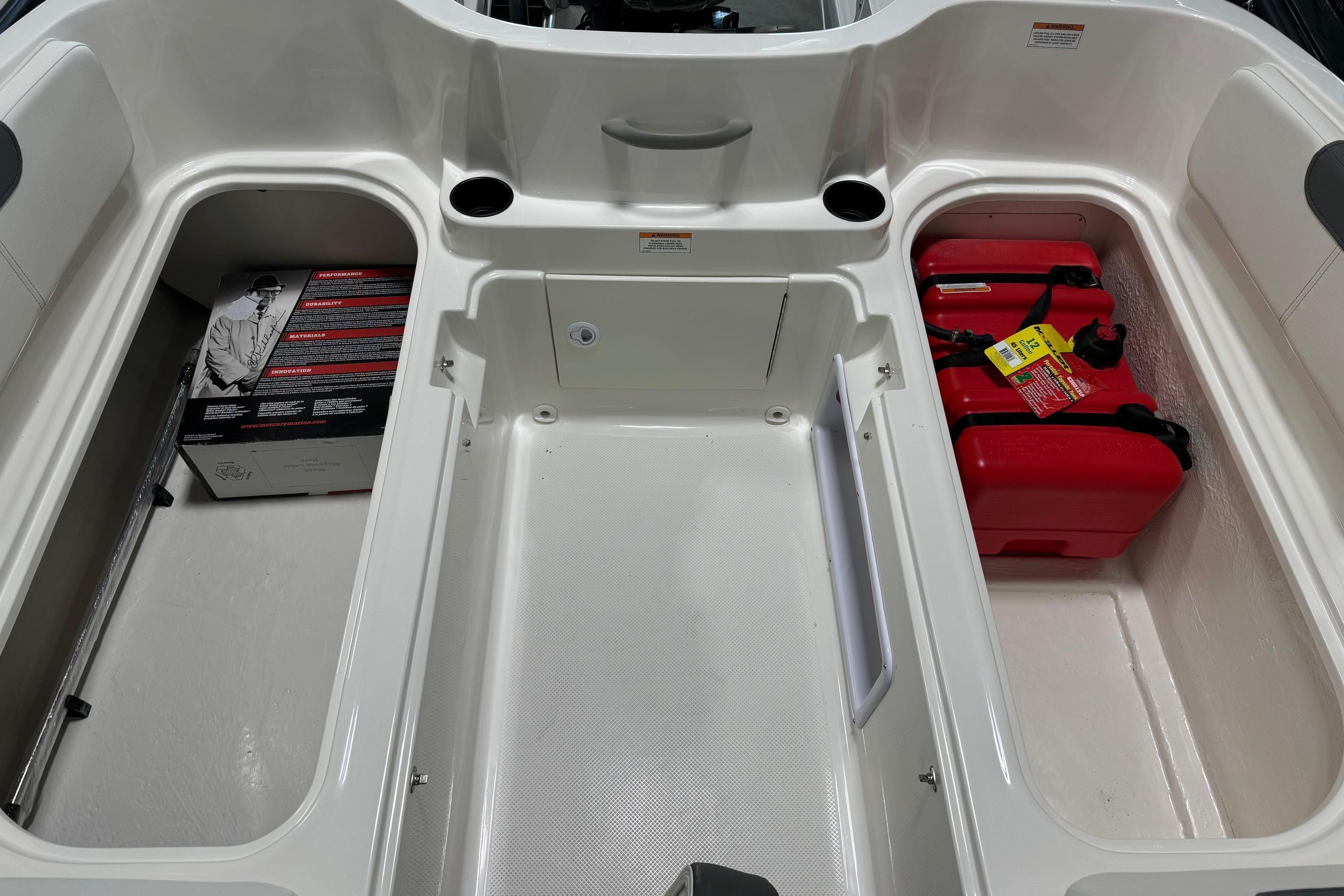 2025 Bayliner Element E18 boat storage compartments with red fuel tanks and additional storage space.
